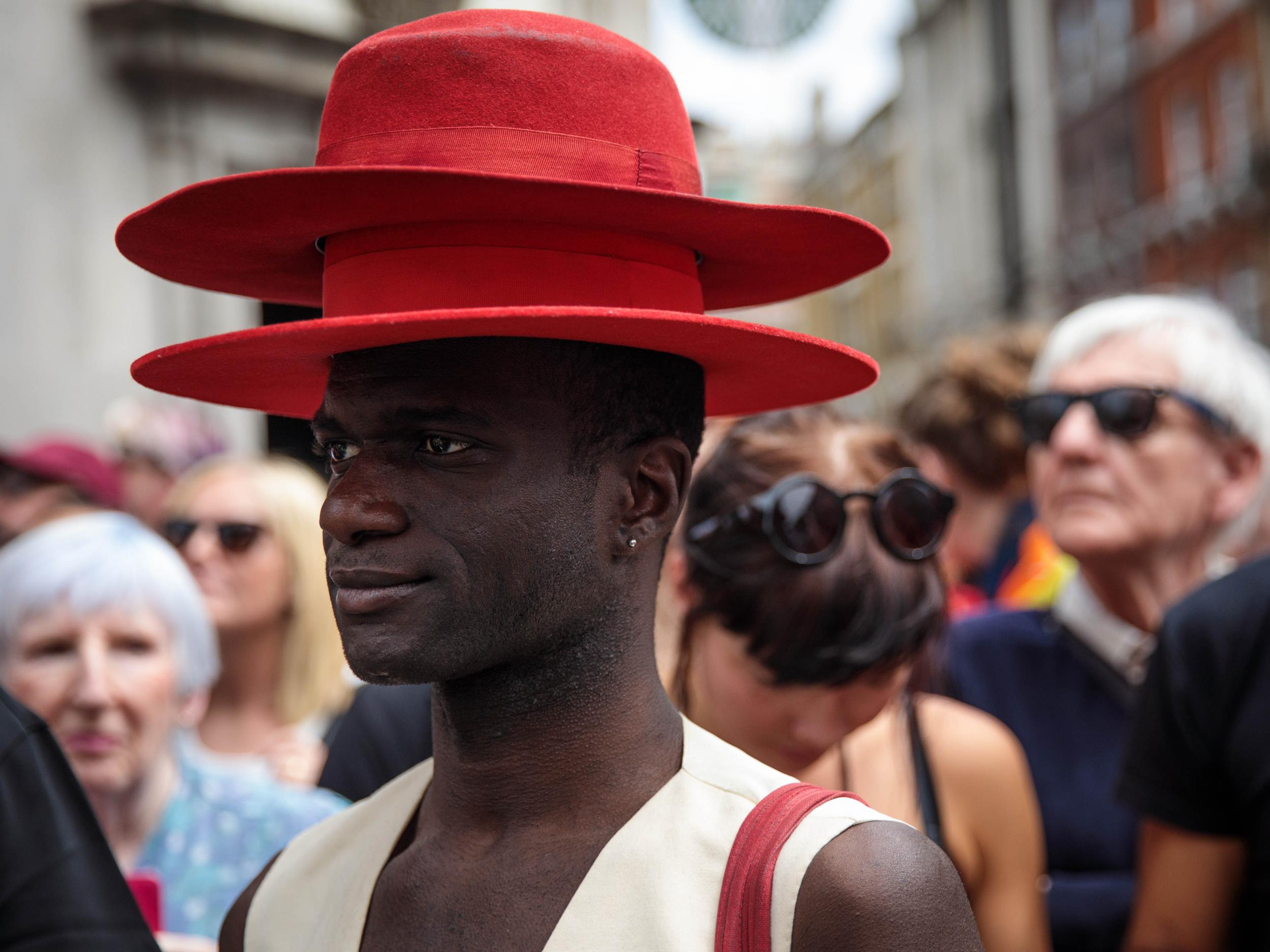 A man wearing two hats attends the Pride in London Festival