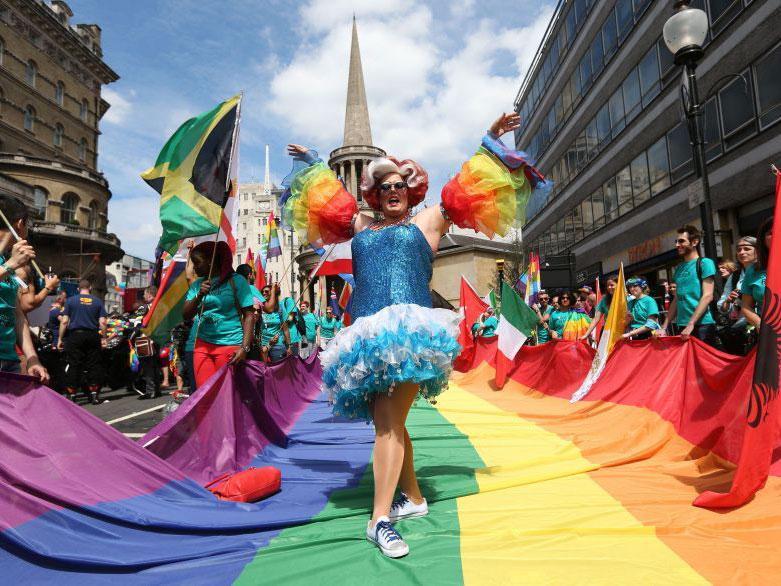 A participant stands on a rainbow coloured flag