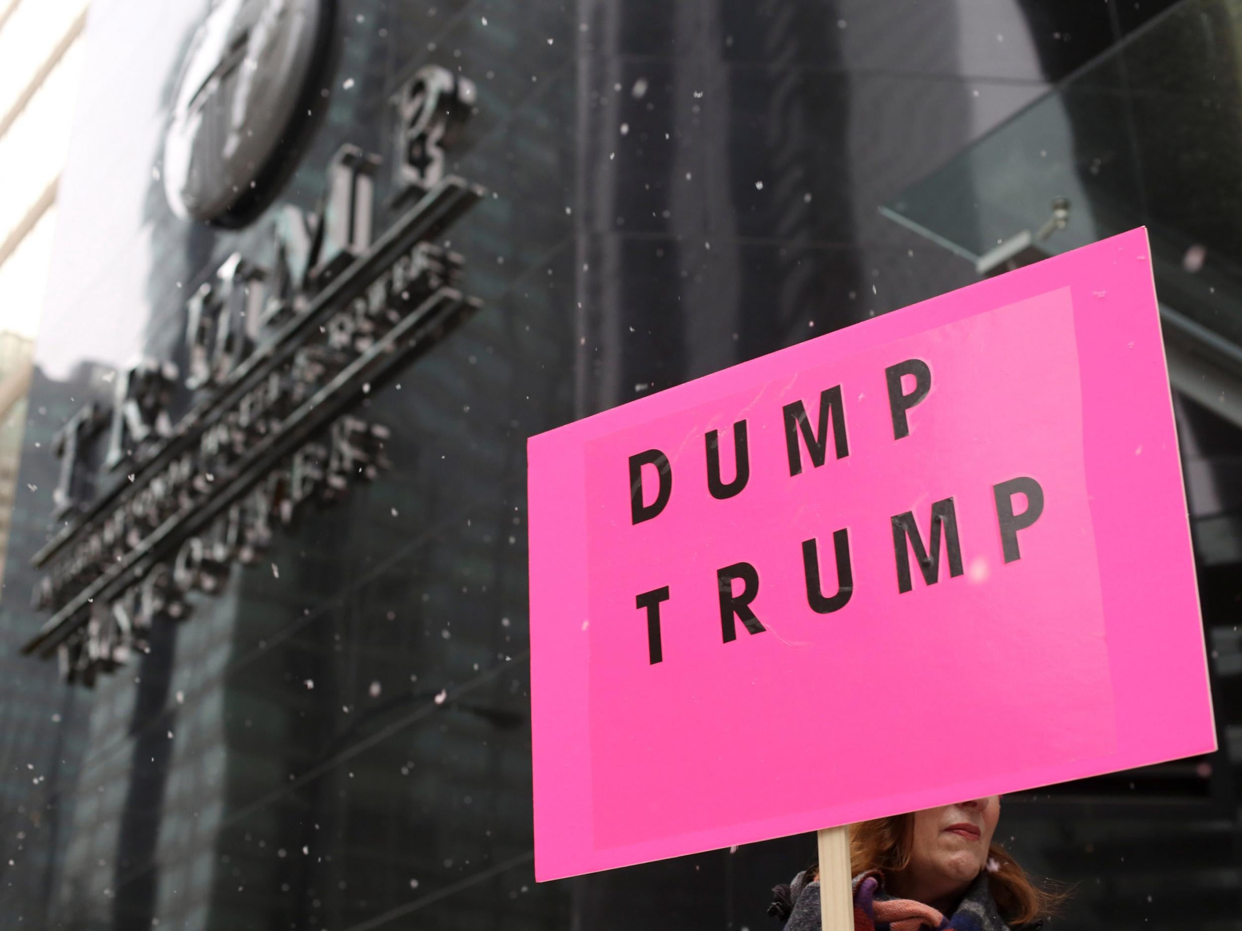 A protester holds a sign during the grand opening of the Trump International Hotel and Tower in Vancouver, Canada, on 28 February 2017