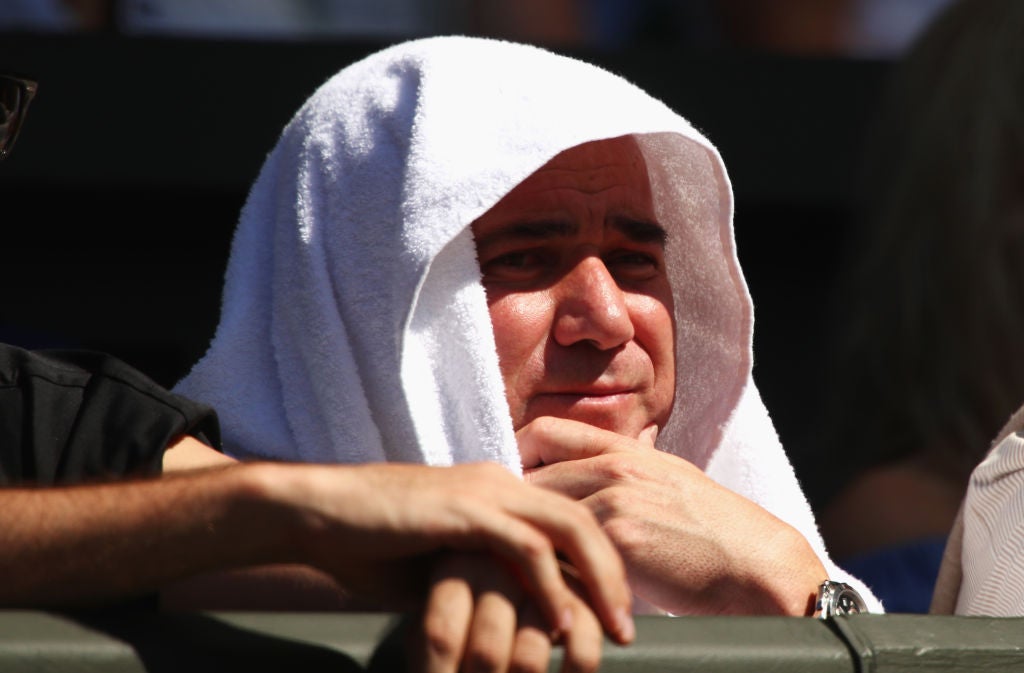 The tennis icon cooled off in the heat by hiding under a white towel