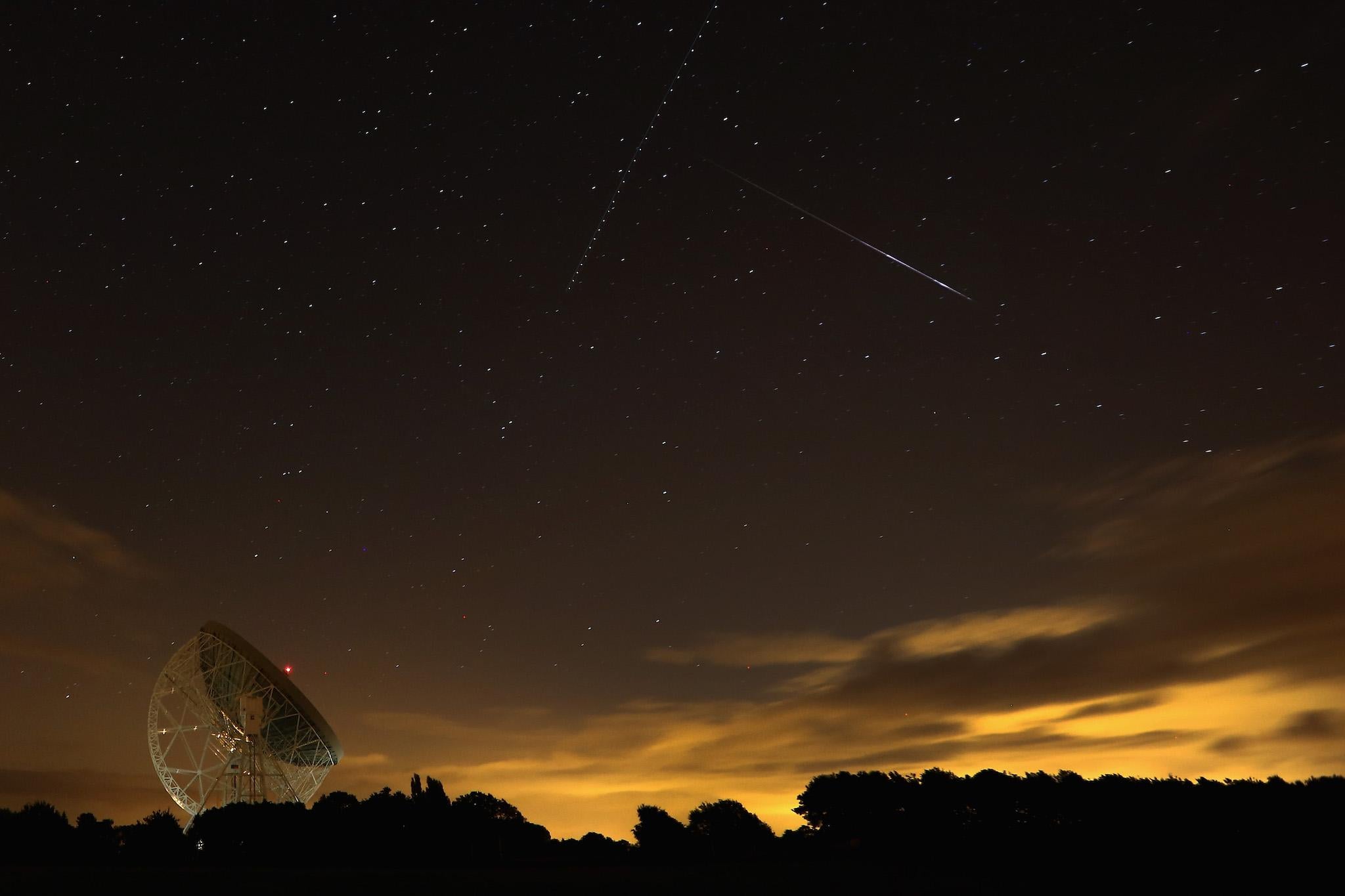 A Perseid meteor streaks across the sky over the Lovell Radio Telescope at Jodrell Bank on August 13, 2013 in Holmes Chapel, United Kingdom