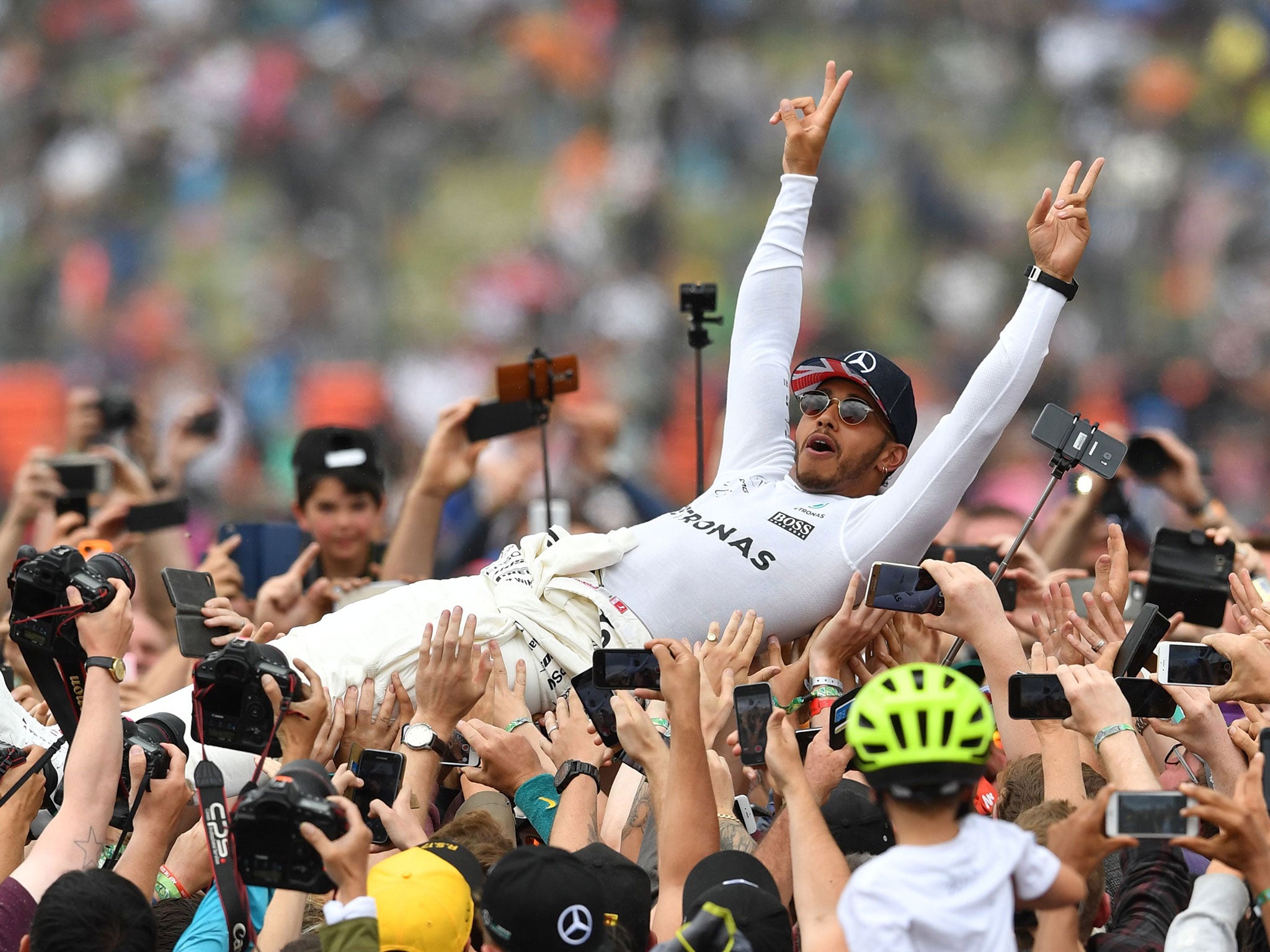 Lewis Hamilton celebrates with fans after winning his fifth Silverstone title