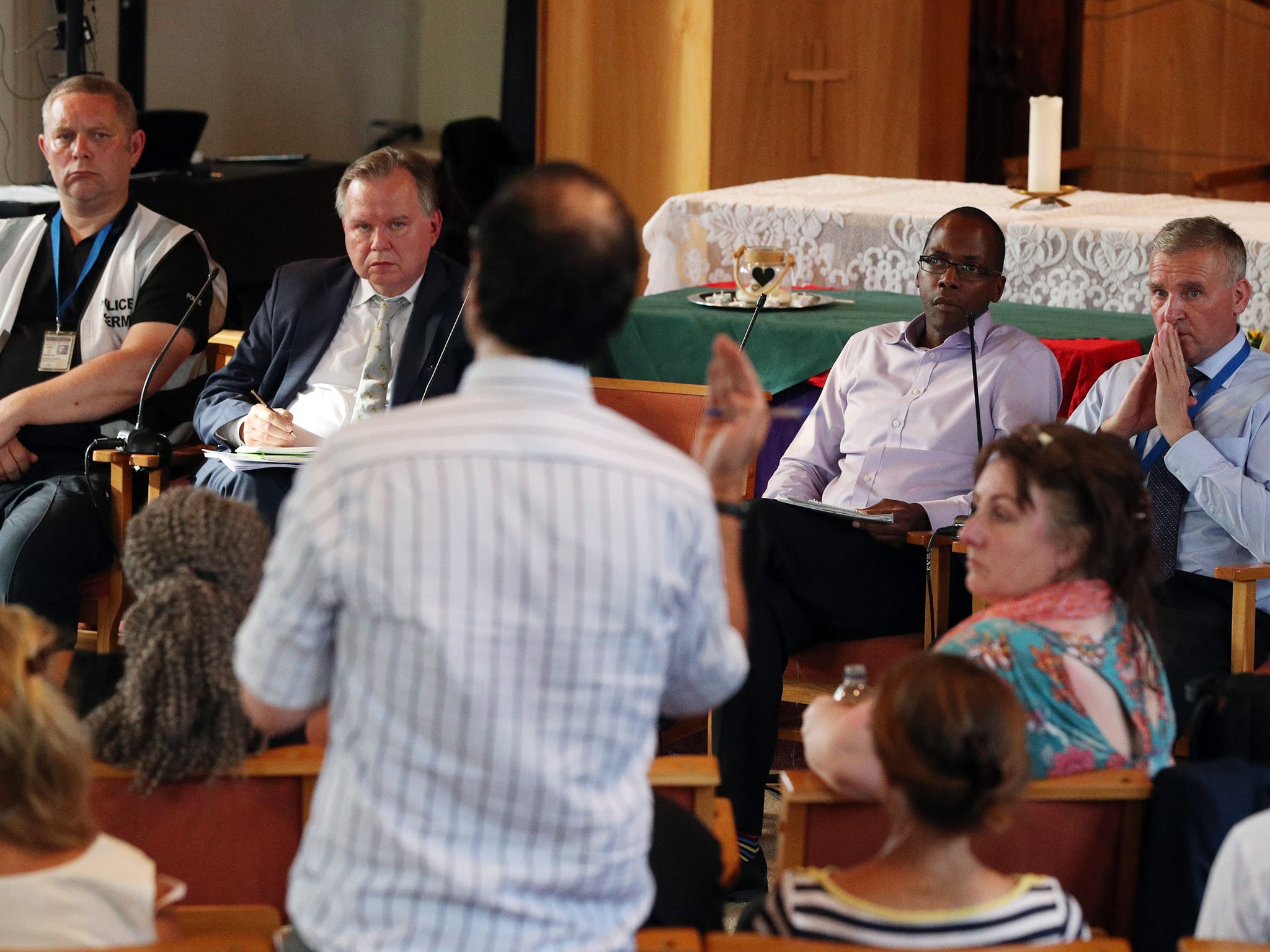 A man speaks during an earlier public meeting between Grenfell residents and authorities