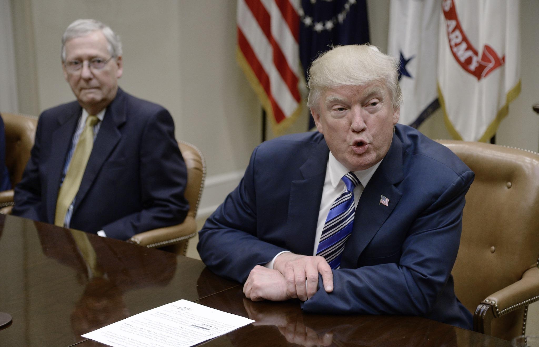 US President Donald Trump speaks as Senate Majority Leader Mitch McConnell looks on