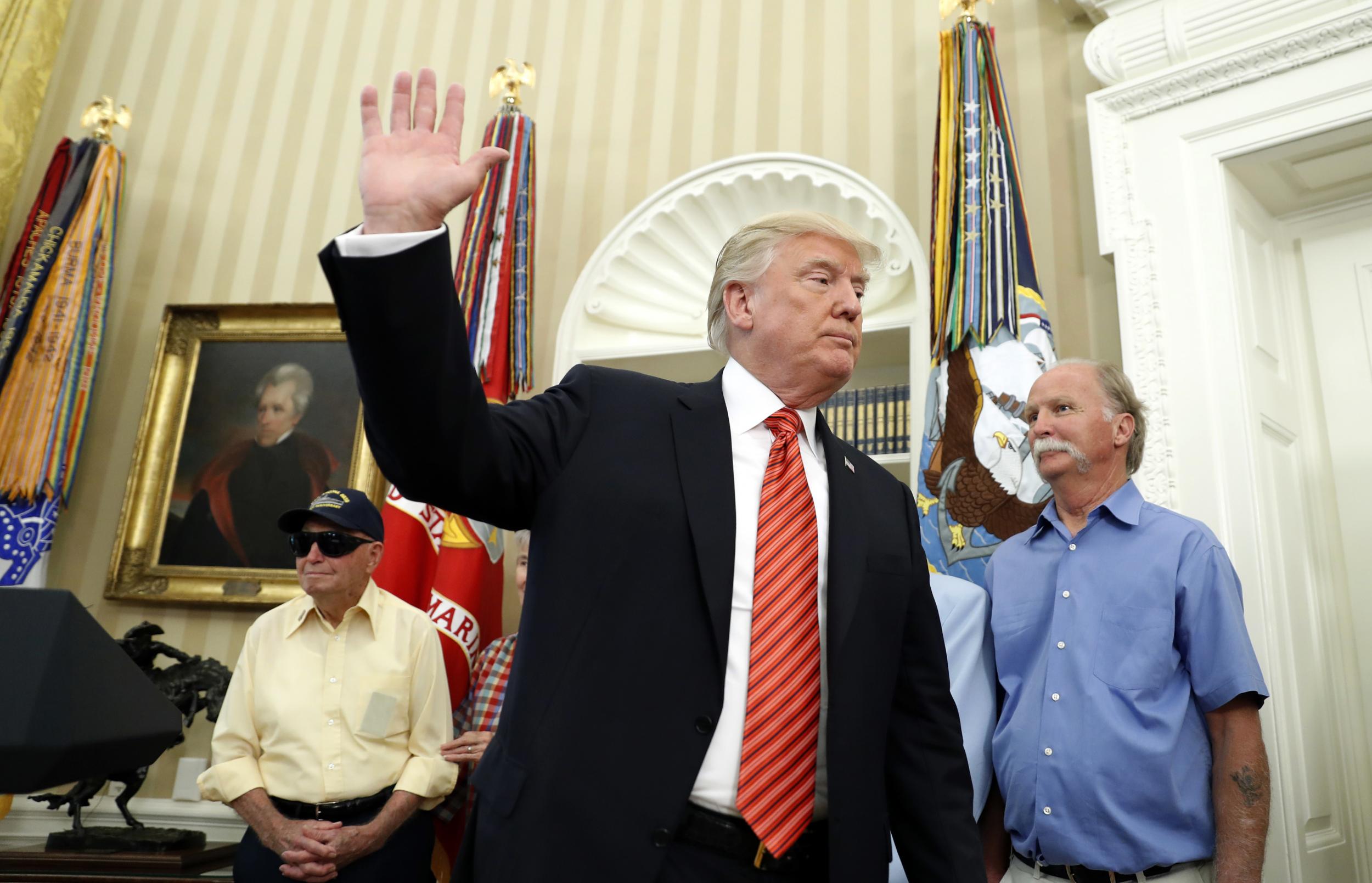 President Donald Trump waves as he departs after a meeting with survivors of the attack on USS Arizona at Pearl Harbor