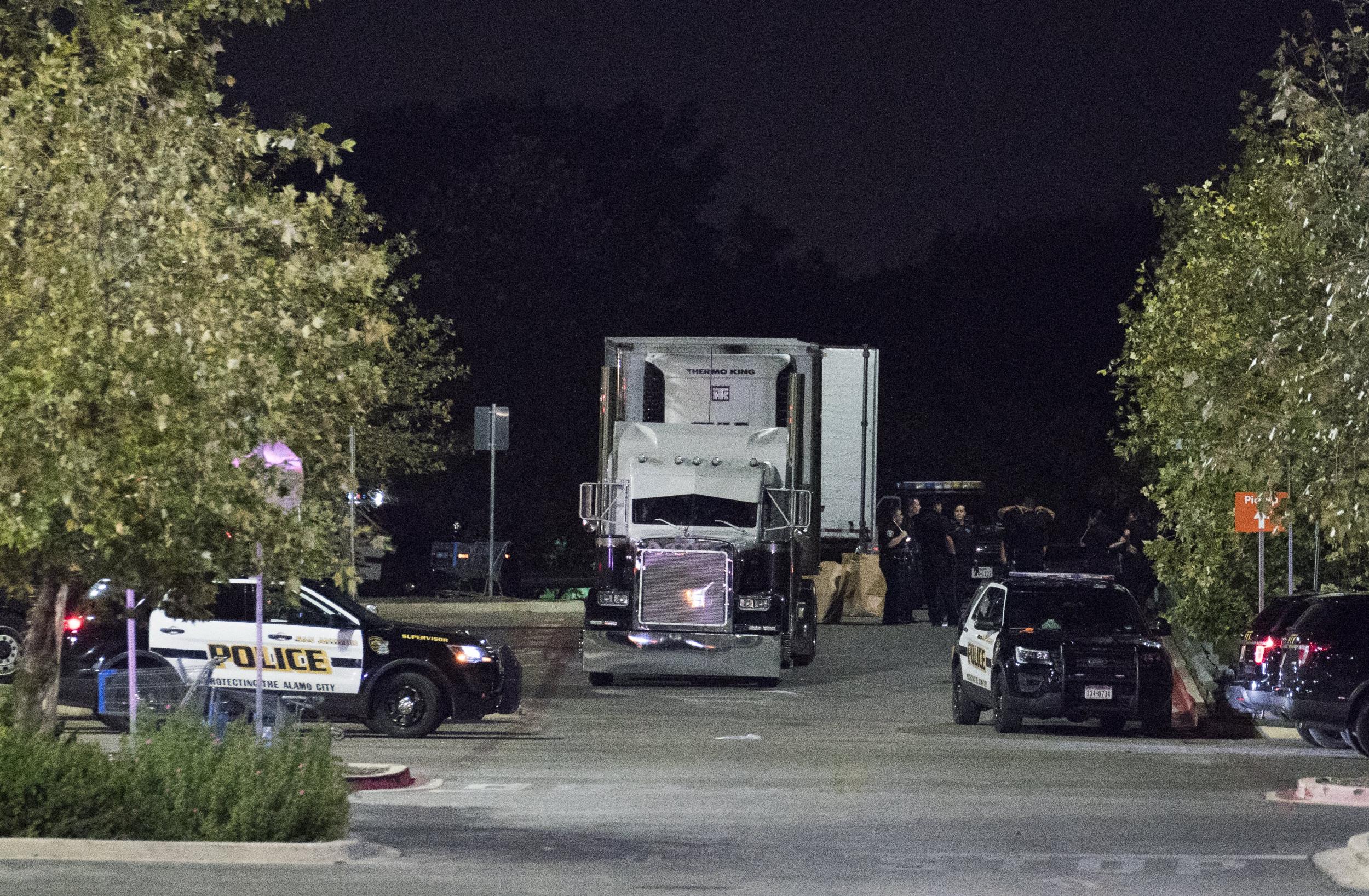 Officials investigate a truck that was found to contain 38 suspected illegal immigrants and eight dead bodiesin San Antonio