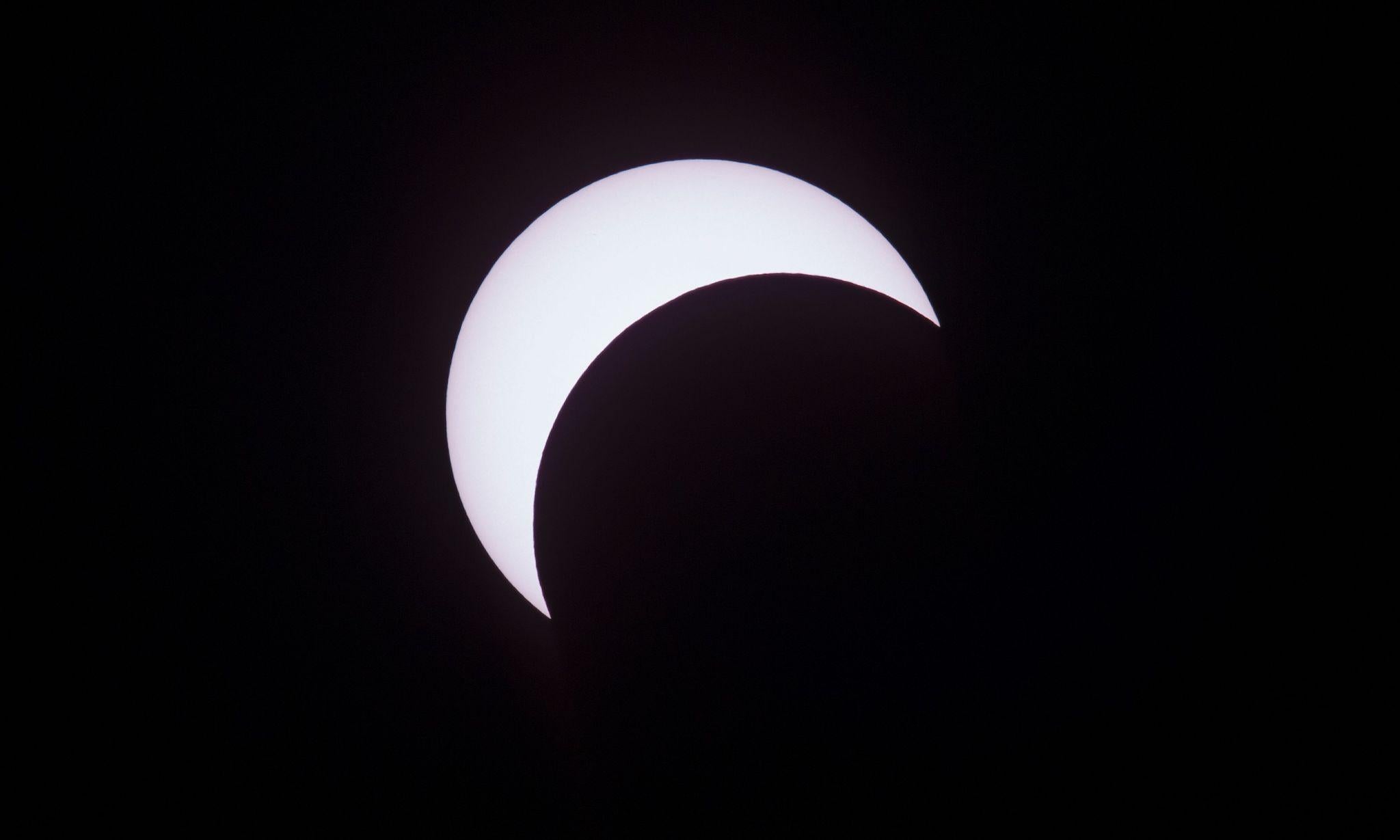 Picture taken on February 26, 2017 showing the moon moving to cover the sun for an annular solar eclipse