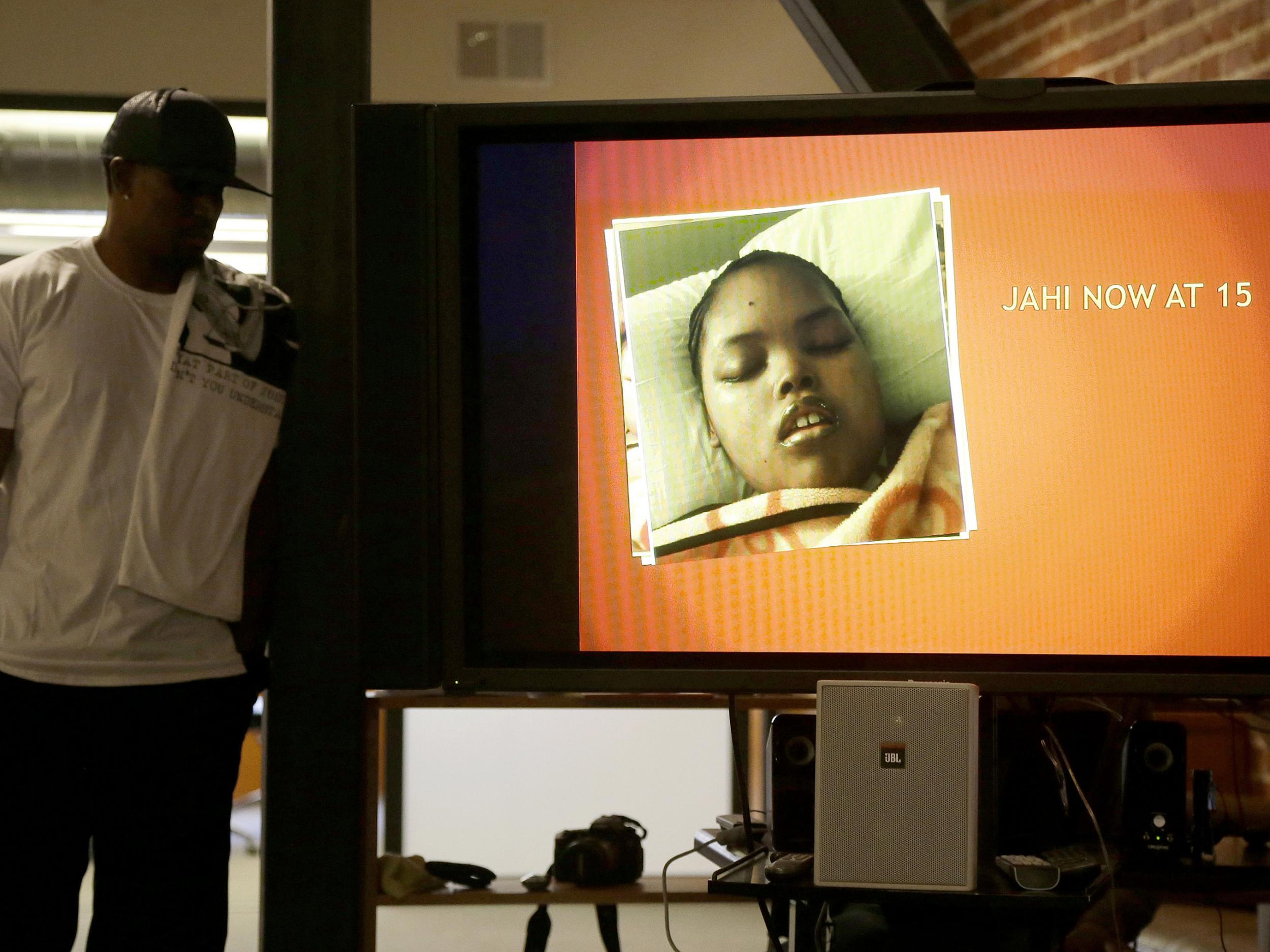 A recent photo of Jahi McMath is shown on a video screen next to her uncle Timothy Whisenton at a news conference in San Francisco