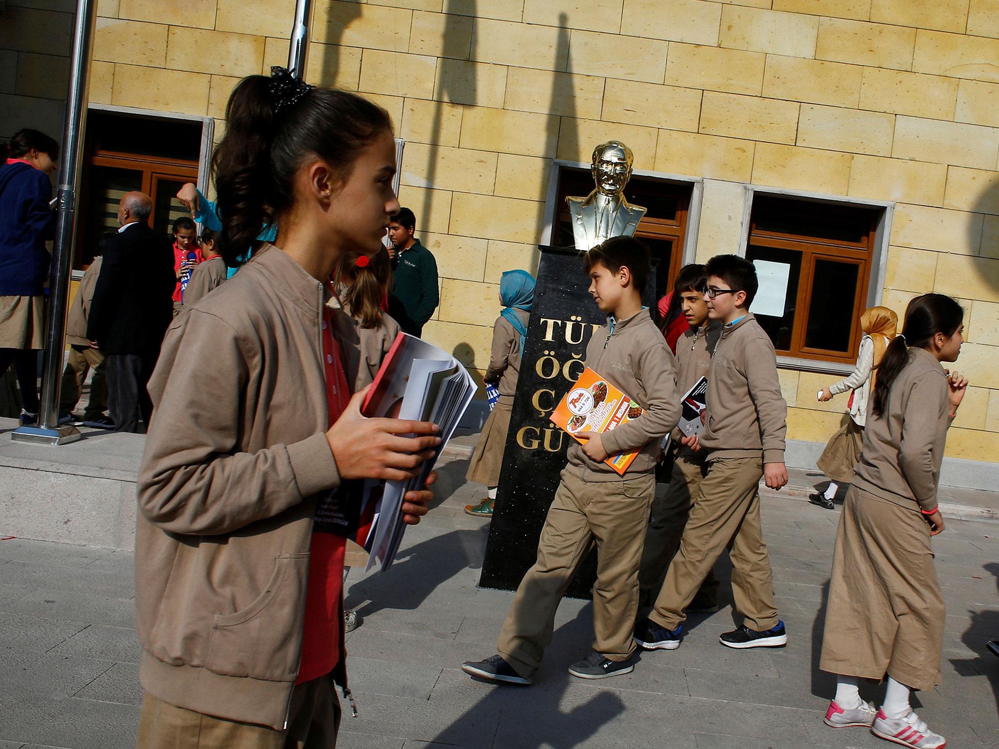 Students at one of Turkey's growing number of 'Imam Hatip' religious schools walk past a statue of Mustafa Kemal Ataturk, founder of secular Turkey, in Ankara