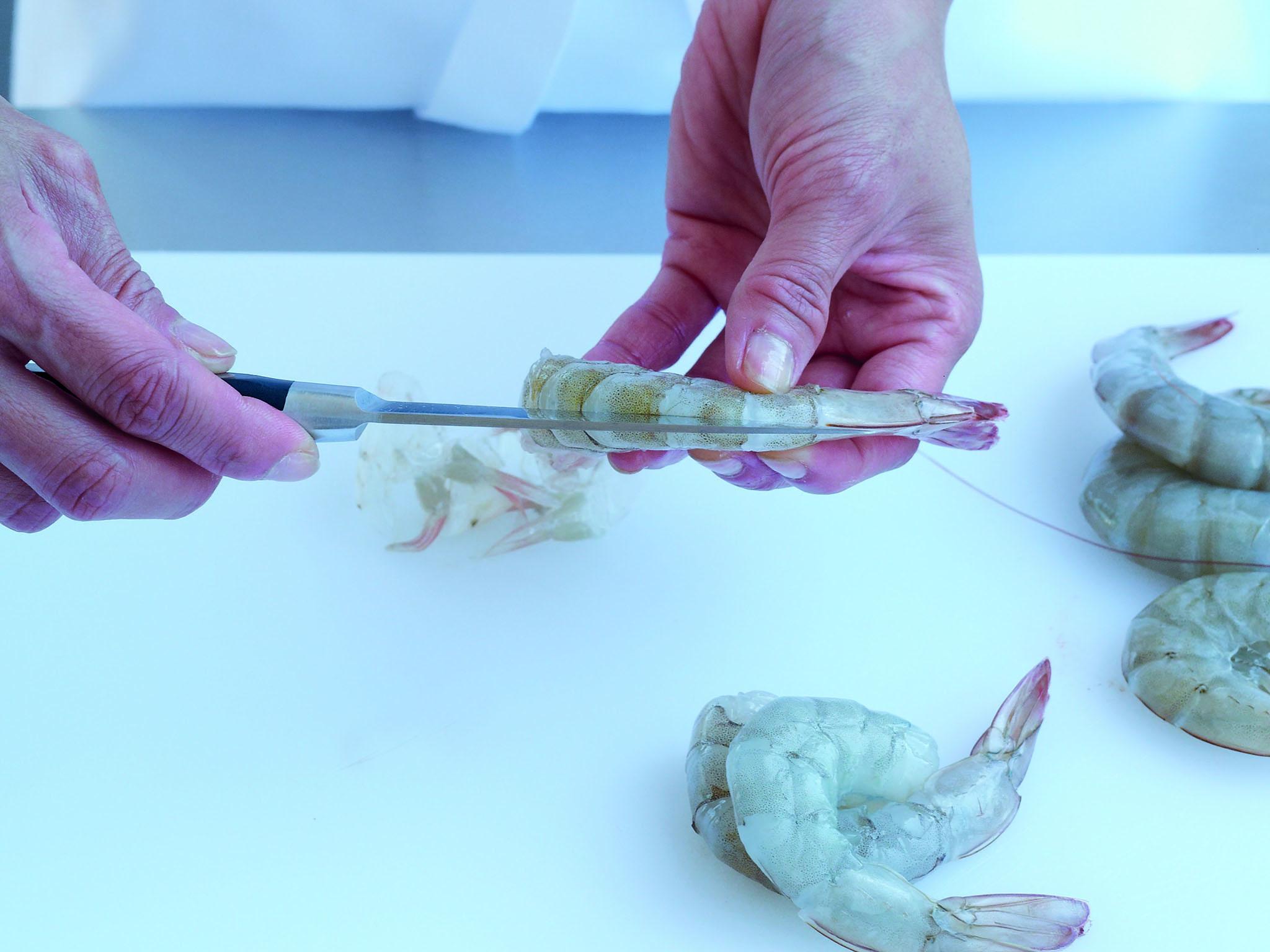 1. Holding the shelled prawn between your fingers and thumb, make a shallow incision, along the length of the back of the tail to expose the intestinal tract. Carefully pull this thread away and discard