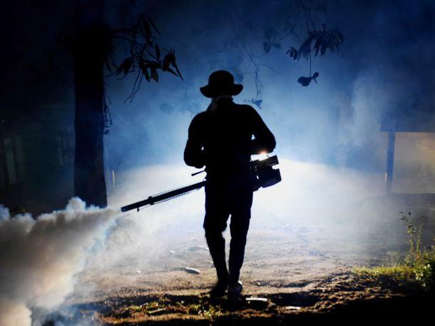 A Sri Lankan health worker sprays a neighbourhood with a fog used to ward off mosquitos in Biyagama on the outskirts of Colombo