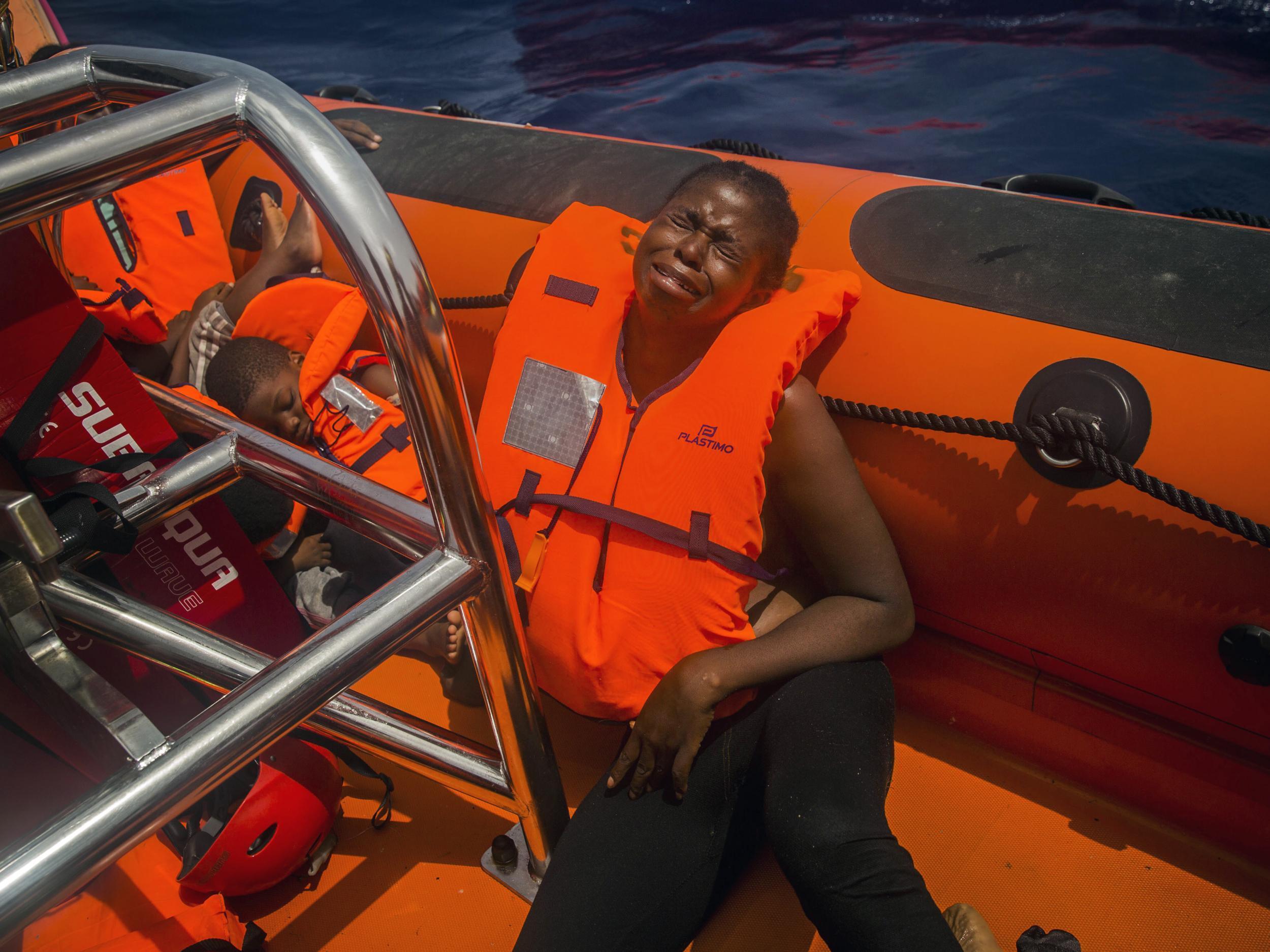 A woman cries after being rescued by aid workers of Spanish NGO Proactiva Open Arms in the Mediterranean Sea, about 15 miles north of Sabratha, Libya