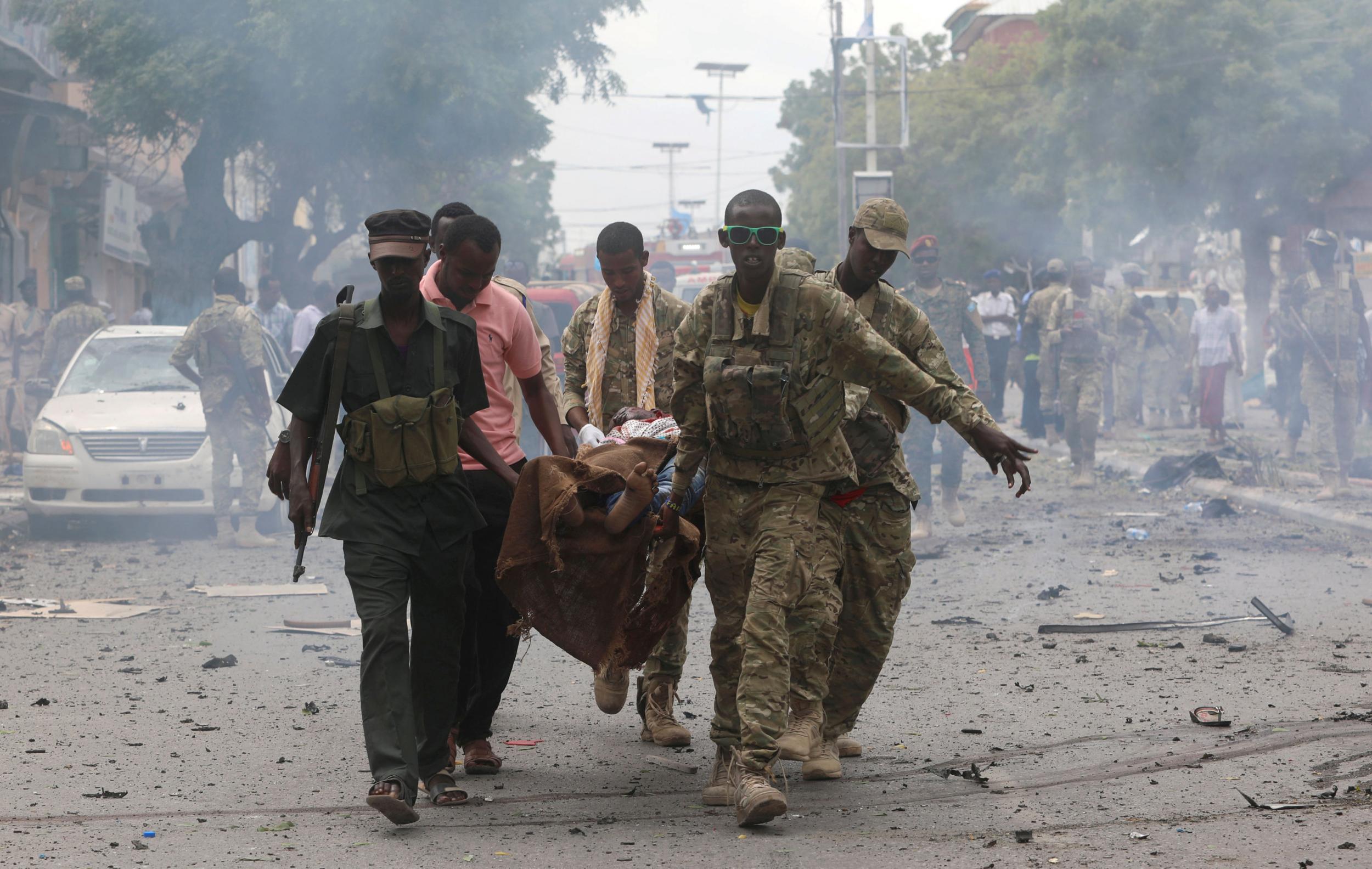 Somali military officers evacuate an injured man from the scene of an explosion in Mogadishu