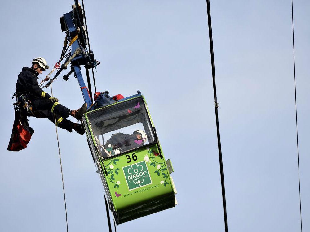 German fire crews evacuating passengers from suspended cable cars