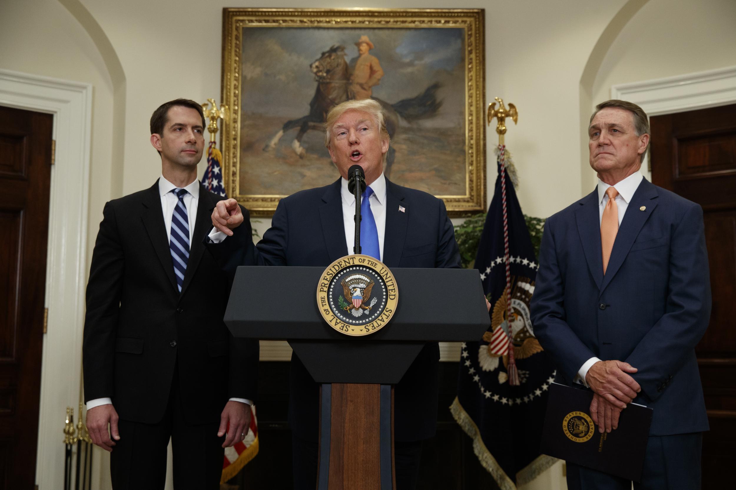 President Donald Trump, flanked by Senator Tom Cotton Senator David Perdue, speaks in the Roosevelt Room of the White House in Washington