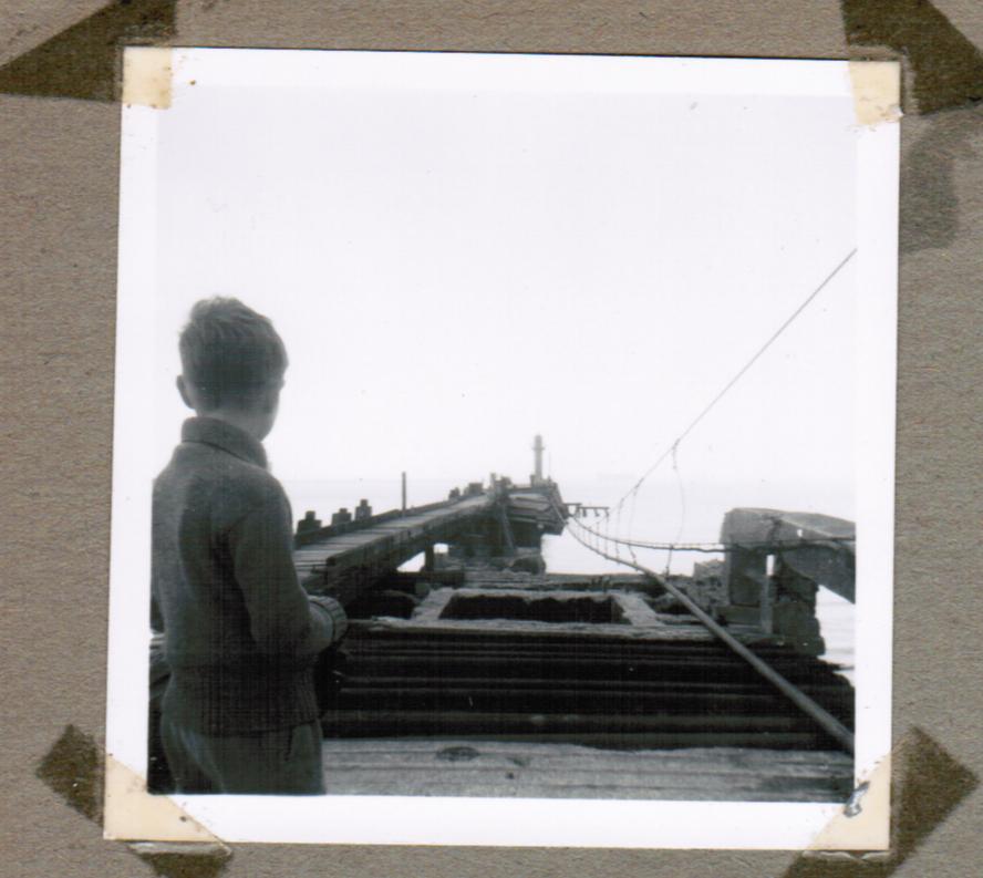 A very young Robert Fisk looks at the Luftwaffe-smashed ‘mole’ at Boulogne – 16 years after British troops evacuated under fire in May 1940 as their comrades stood on the beaches of neighbouring Dunkirk (Peggy Fisk)