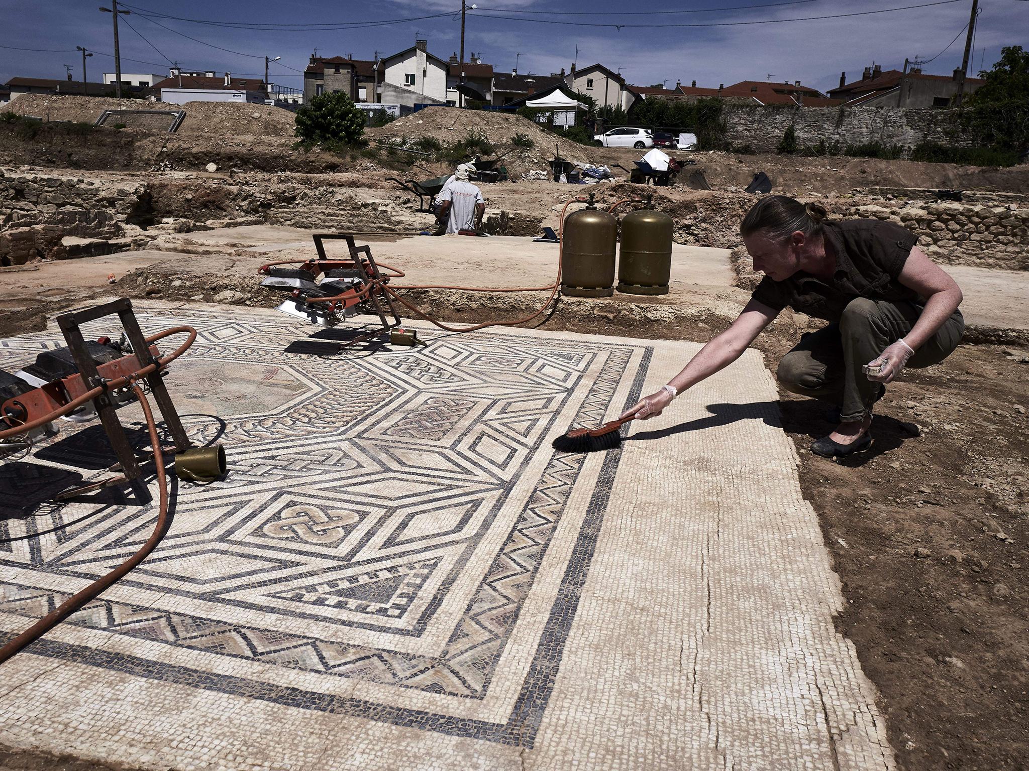 An archaeologist works on the site, where a philosophy school, shops and lavish residences decorated with mosaics have been found