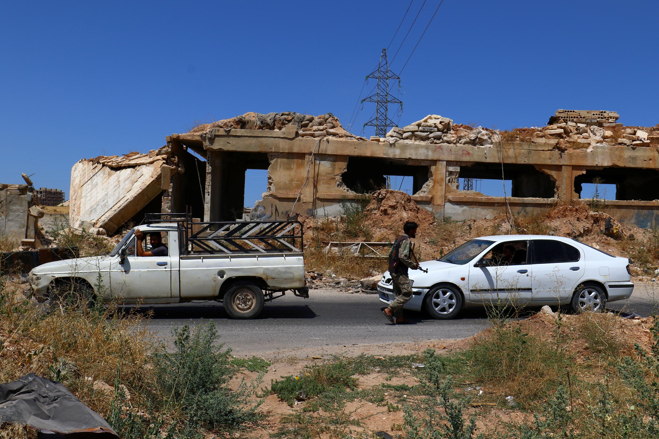 Members from the Jaish al Fateh rebel coalition operate a checkpoint in Idlib City on 18 July 2017