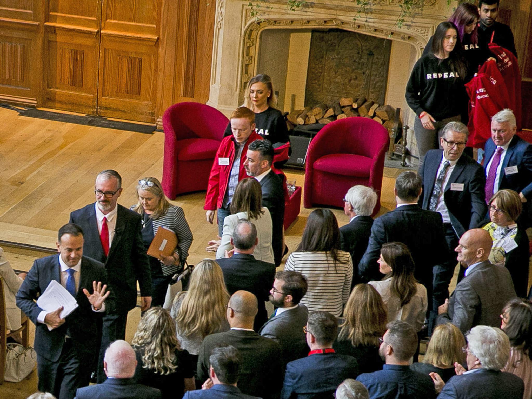 Irish Taoiseach Leo Varadkar (bottom L) walks away from women wearing 'repeal' T-shirts after his speech