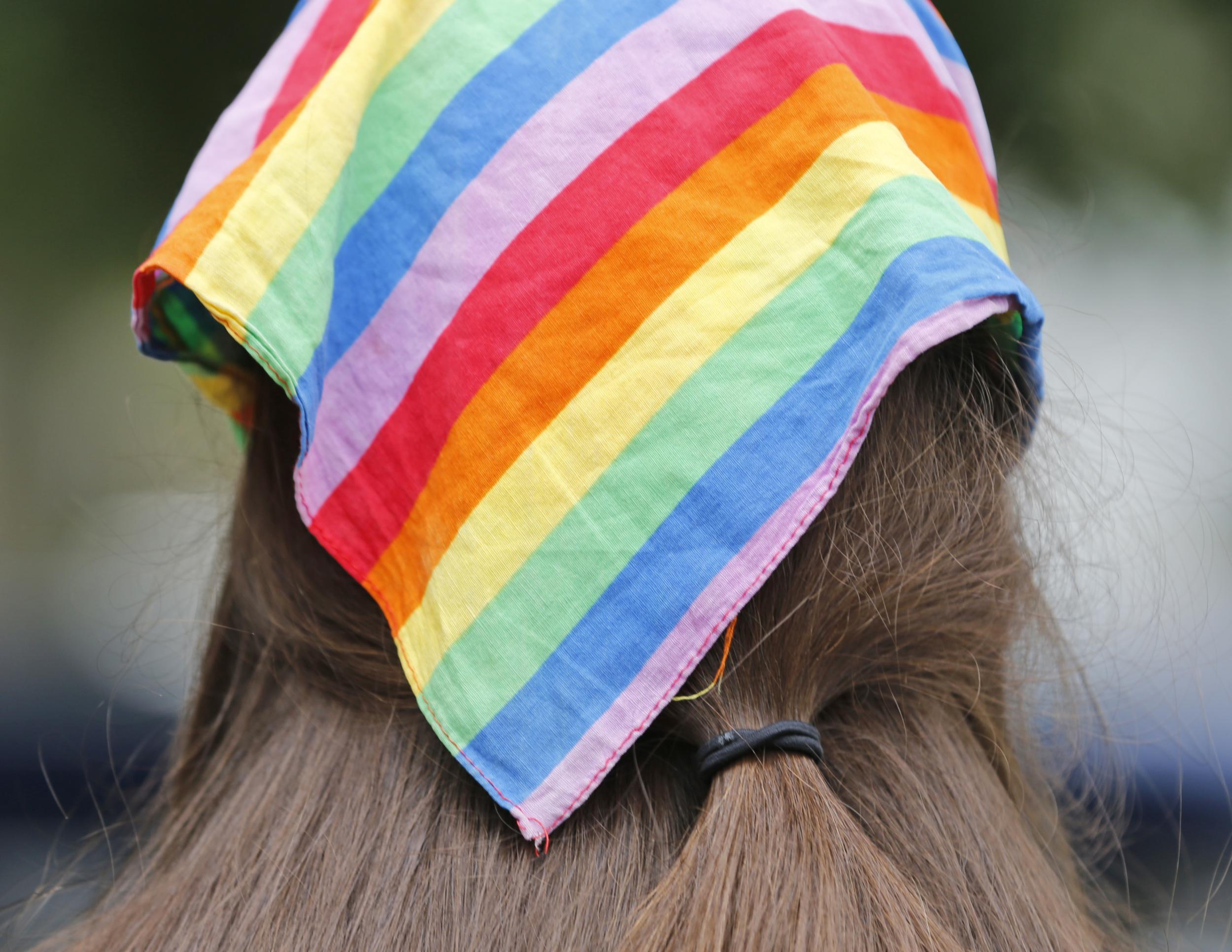 A woman wears a rainbow scarf symbolising LGBTQ pride