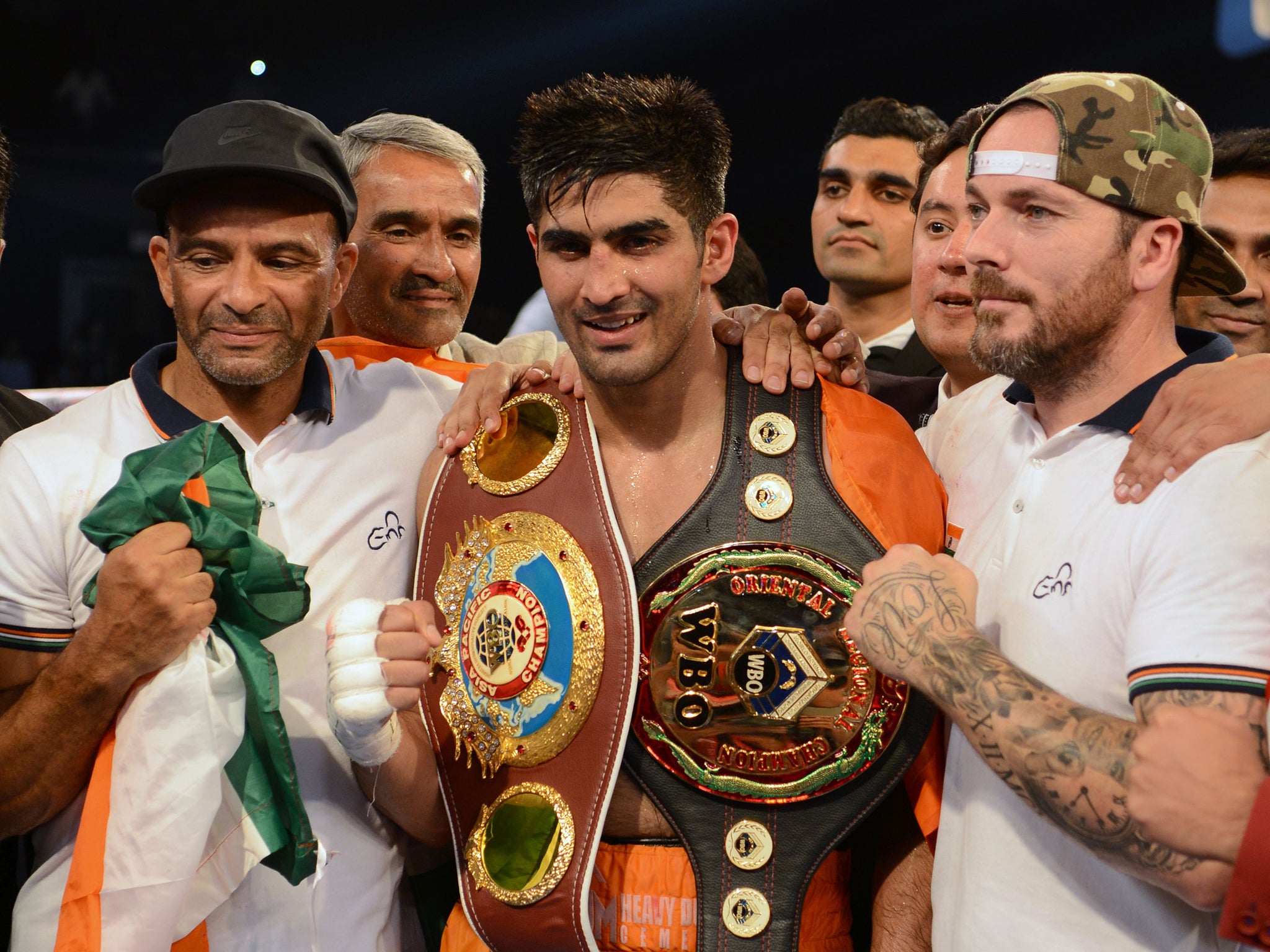 Indian boxer and WBO Asia-Pacific Super Middleweight champion Vijender Singh (C) celebrates after winning the double title bout against China's Zulpikar Maimaitiali at the National Sports Complex of India (NSCI) Dome in Mumbai on August 5, 2017. / AFP PHOTO / PUNIT PARANJPEPUNIT PARANJPE/AFP/Getty Images