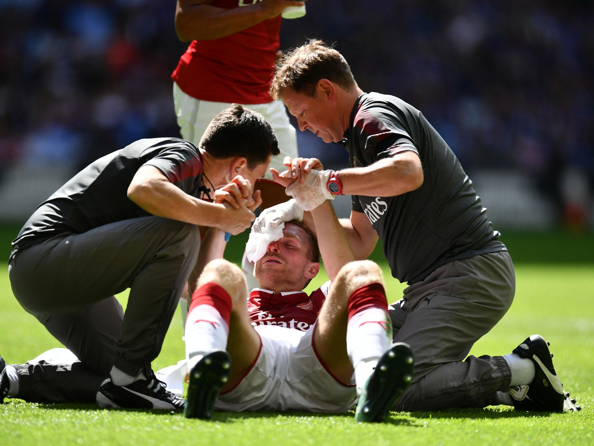 Per Mertesacker was forced off early after taking a blow to the head