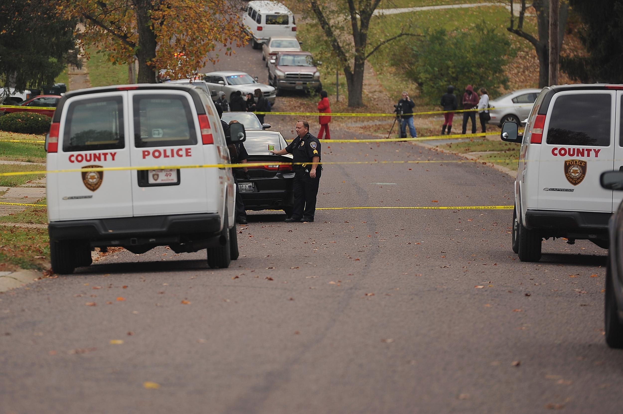 Missouri police officers stand within a crime scene perimeter in an unrelated incident