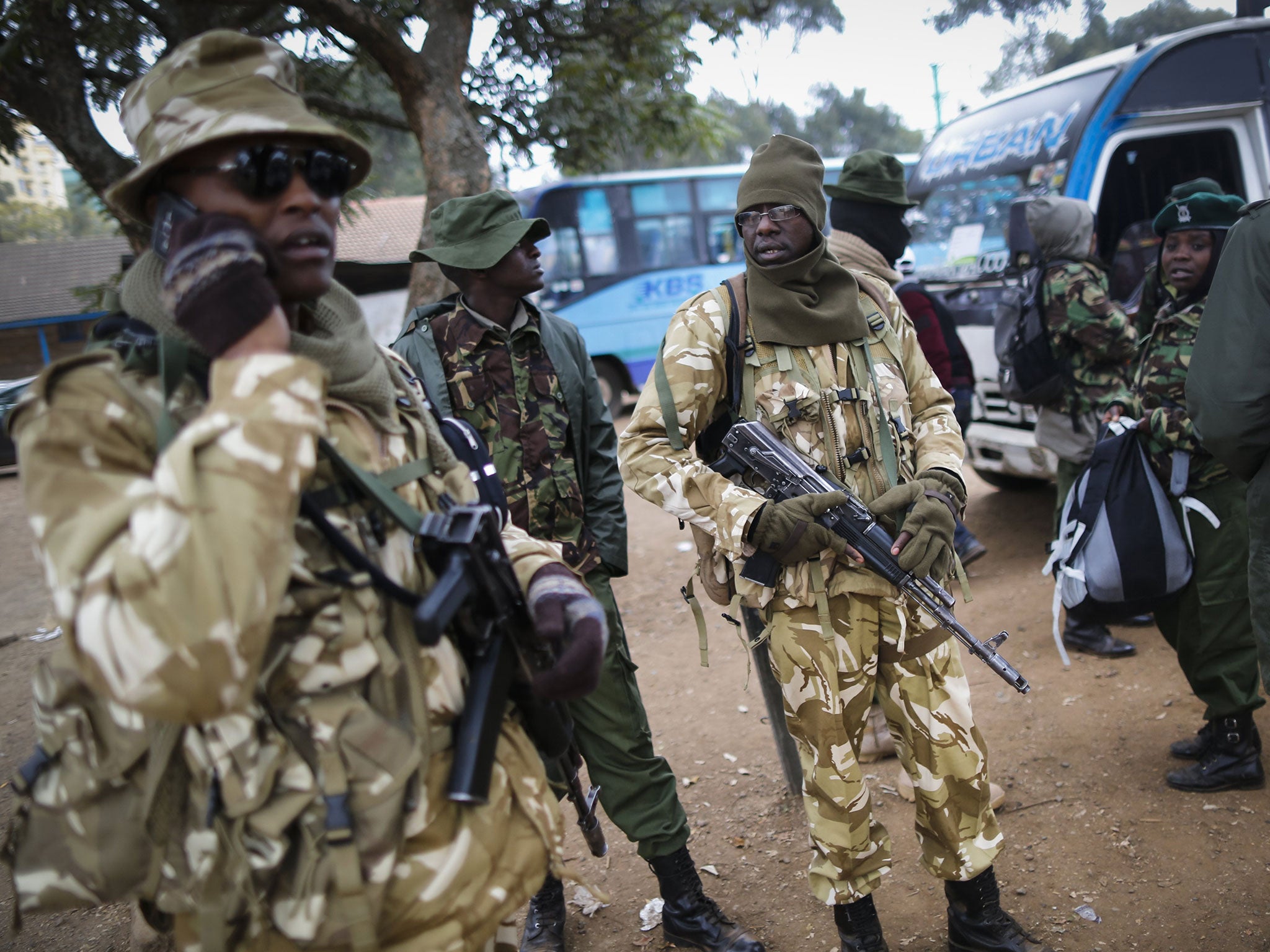 Police officers and rangers of the Kenya Wildlife Service (KWS) look on after escorting buses transporting ballot boxes to one of the main tallying centers in Nairobi