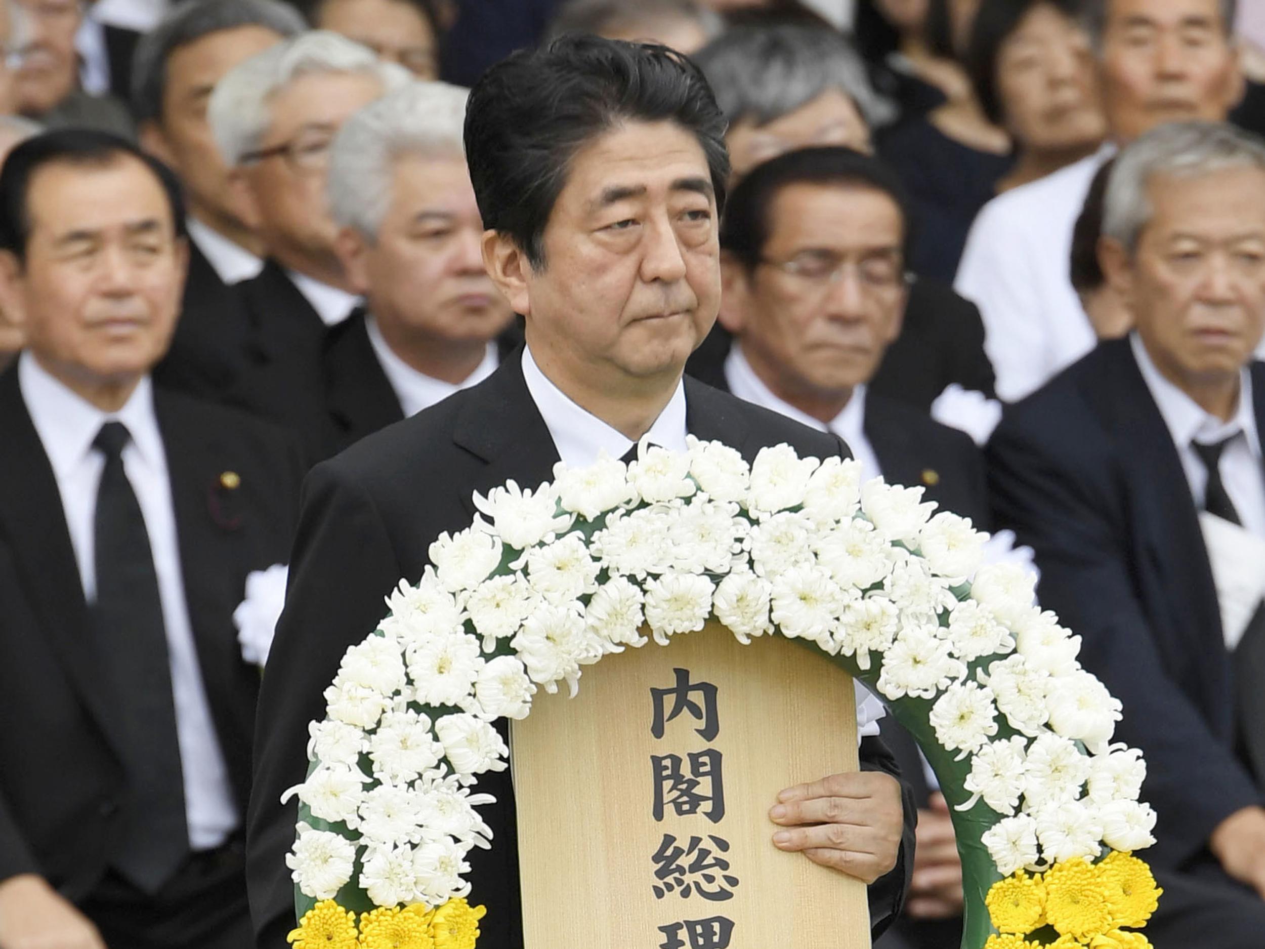 Japan's Prime Minister Shinzo Abe offers a wreath at Nagasaki Peace Park in Nagasaki, southern Japan during a ceremony to mark the 72nd anniversary of the world's second atomic bomb attack over the city