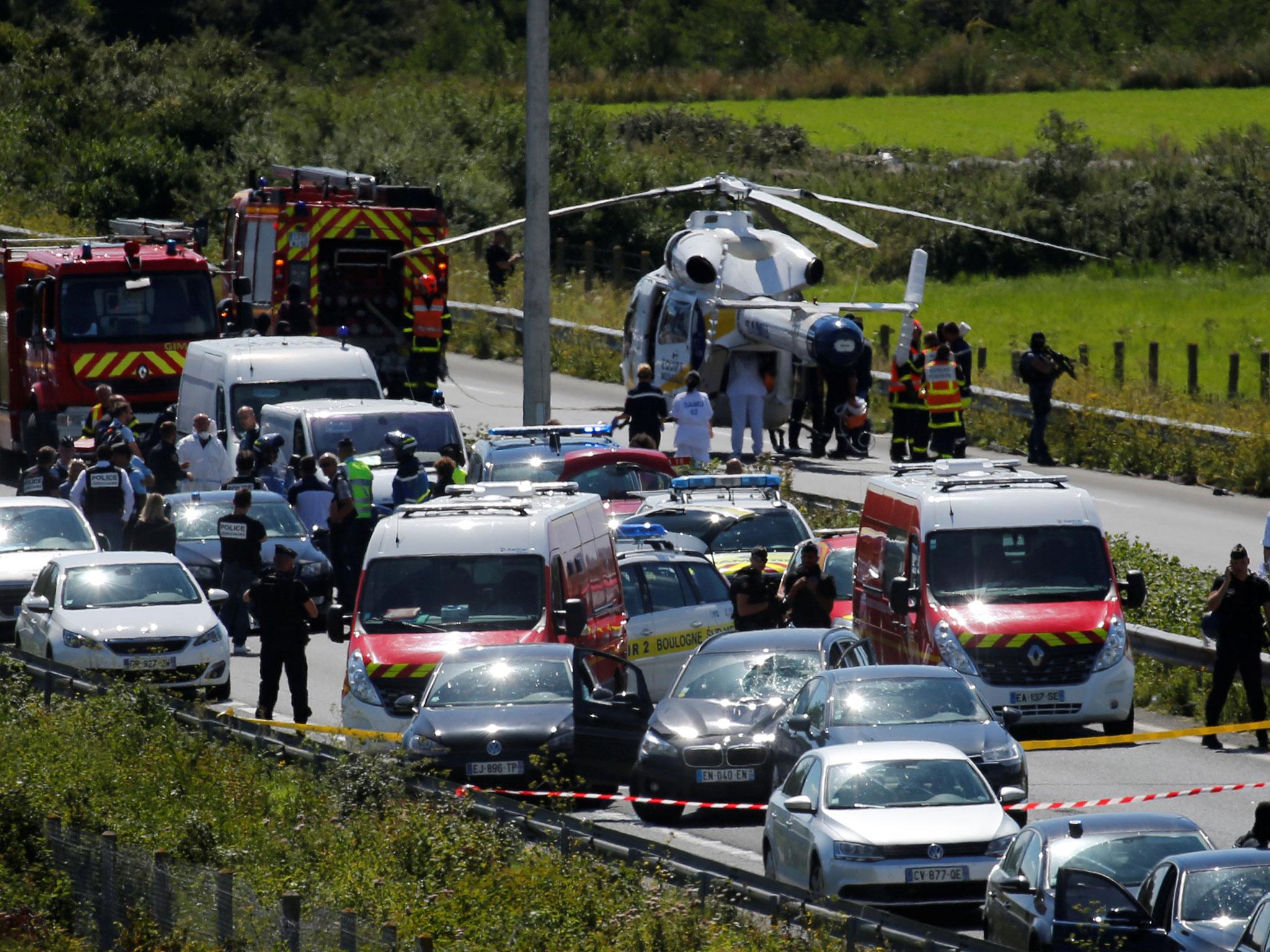 Police and rescue forces surround a BMW car with several bullet holes in it at the scene where the man suspected of ramming a car into a group of soldiers was shot and arrested on the A16 motorway, near Marquise, France