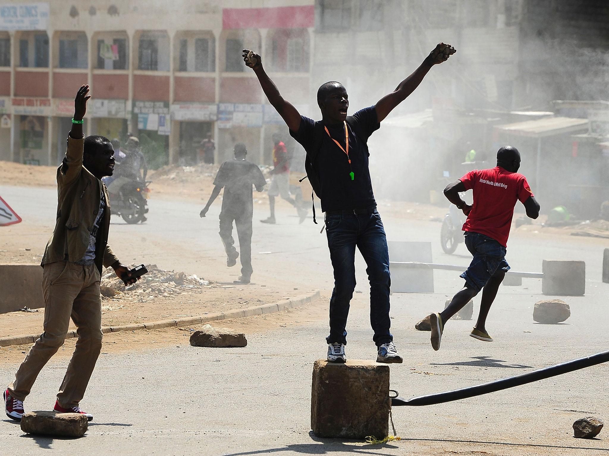 Supporters of Kenya's National Super Alliance shout slogans as they set fire to barricades in Kisumu