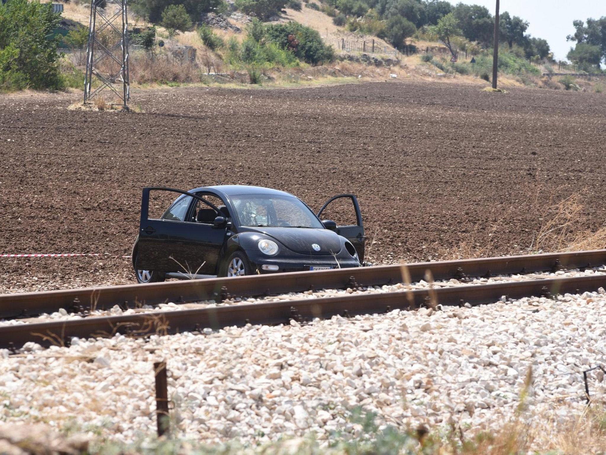 A car stands at the scene where a suspected mafia clan boss and his brother-in-law were shot dead