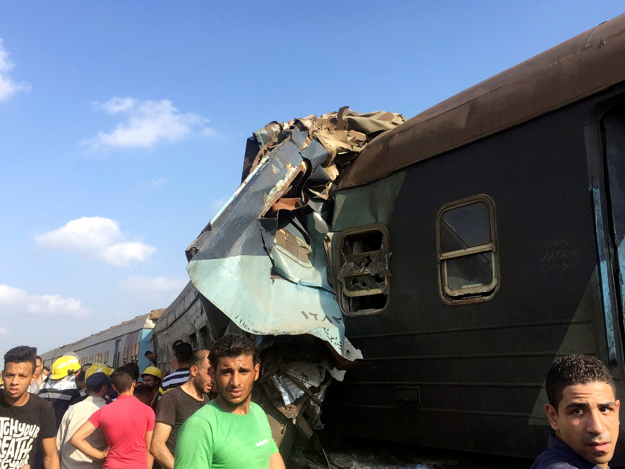 Egyptians look at the crash of two trains that collided near the Khorshid station in Egypt's coastal city of Alexandria