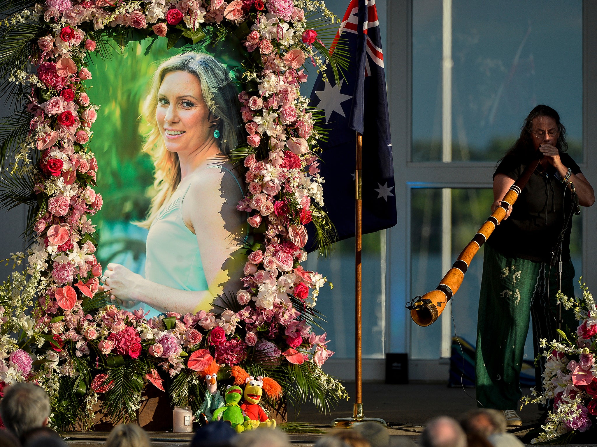 Johanna Morrow plays the didgeridoo during a memorial service for Justine Damond Friday, Aug. 11, 2017, at Lake Harriet in Minneapolis. Damond was killed by a Minneapolis police officer on July 15 after she called 911 to report a possible sexual assault near her home.