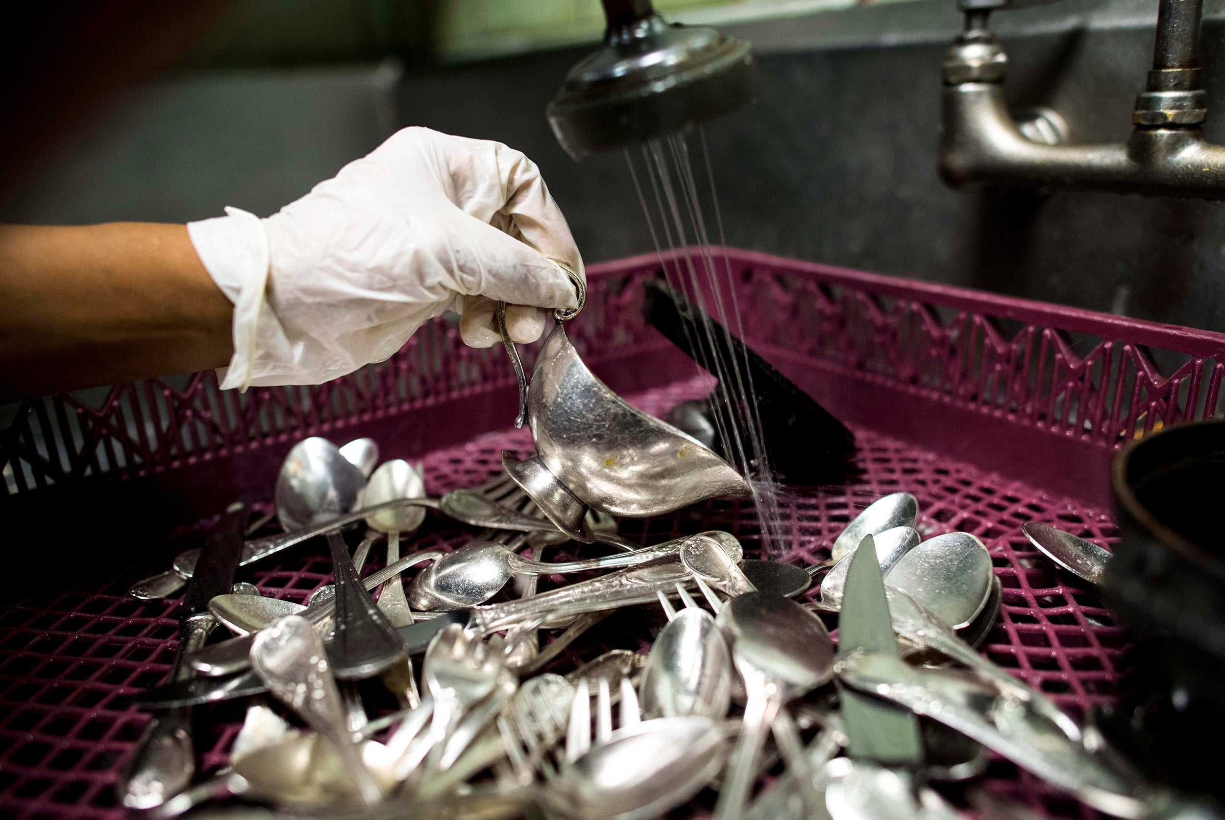 &#13; A pot washer at Manhattan restaurant Daniel cleans silverware during dinner service &#13;