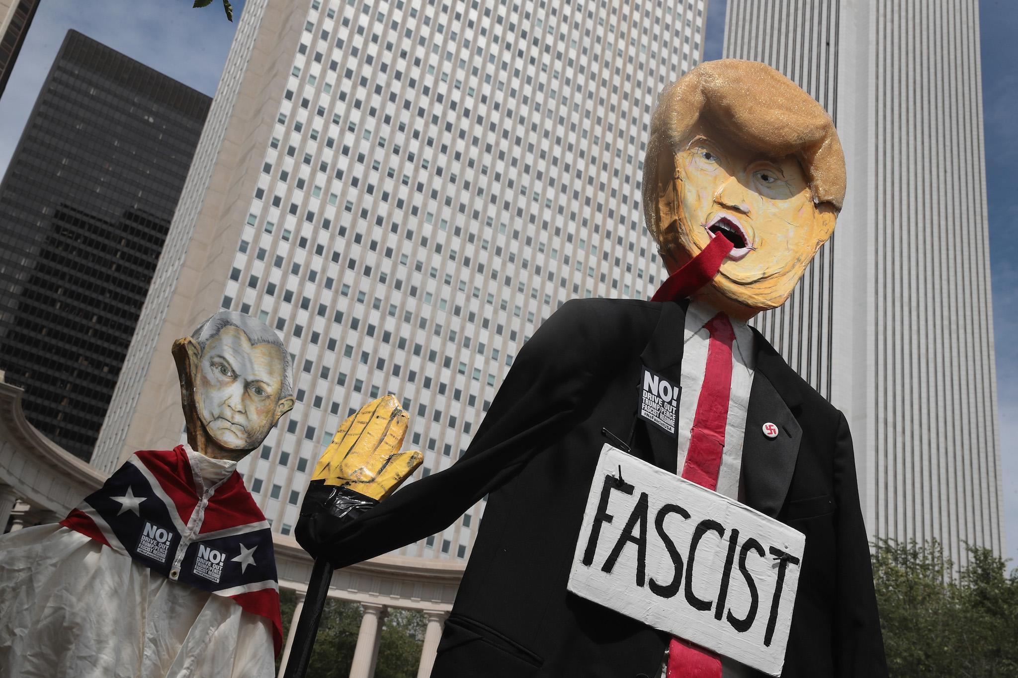 Demonstrators protesting the alt-right movement and mourning the victims of yesterdays rally in Charlottesville, Virginia carry puppets of President Donald Trump and U.S. Attorney General Jeff Sessionson August 13, 2017 in Chicago, Illinois