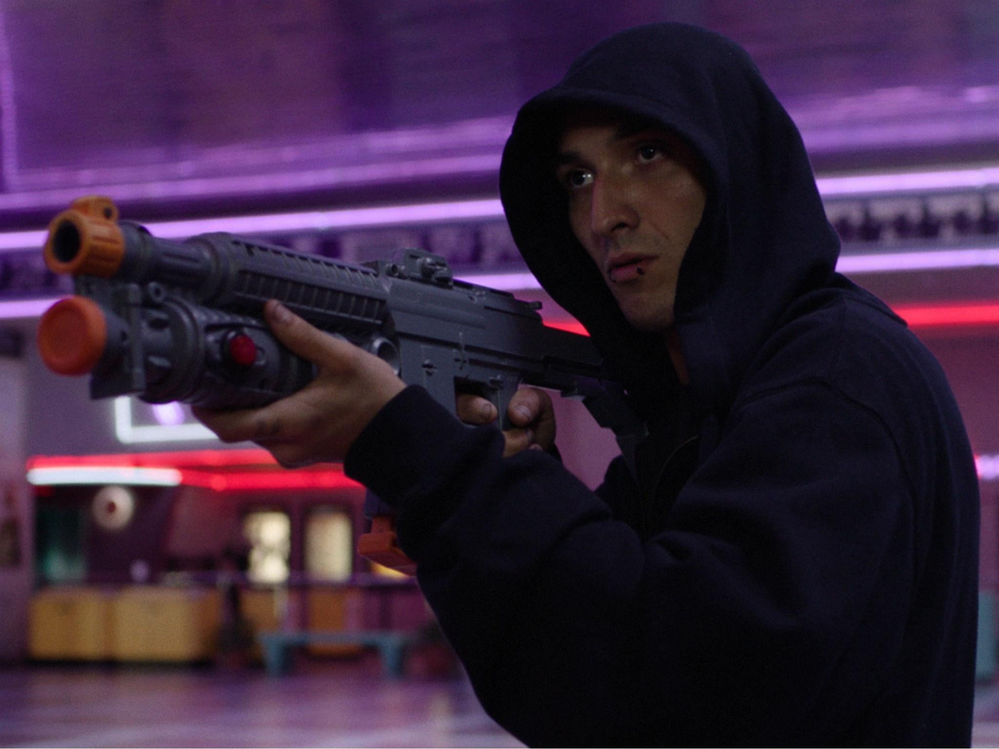 A Sarasota skater (Andres Vega) plays an arcade shoot-out simulator before the screening of the film in Tim Sutton's 'Dark Night'