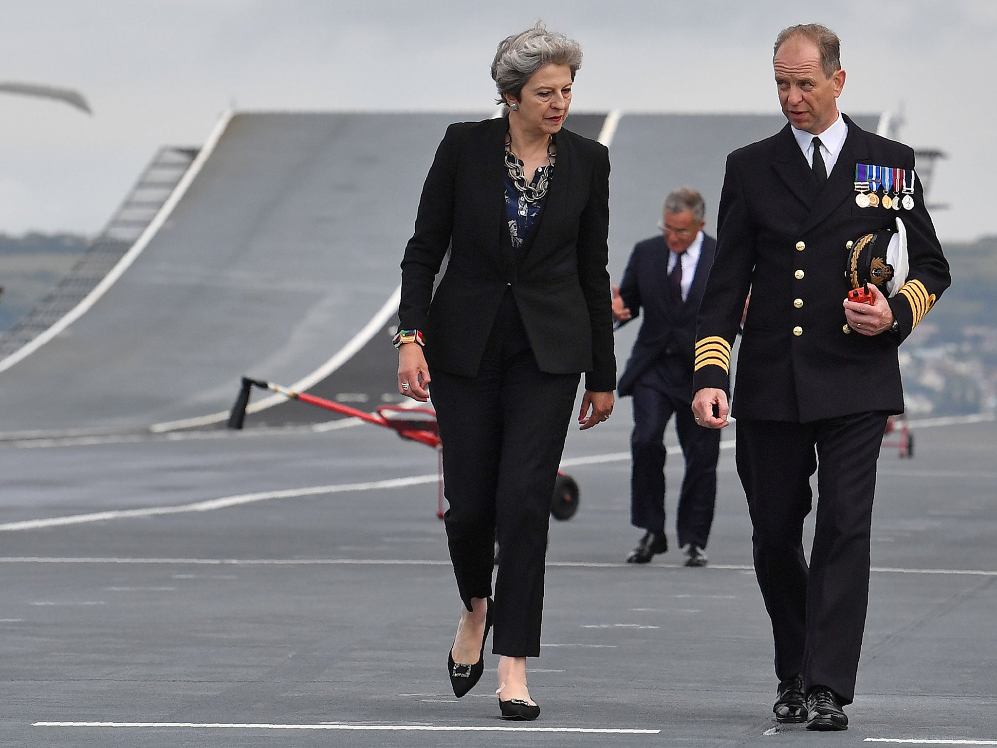 Theresa May talks with Commodore Jerry Kyd (2L), Captain of the 65,000-tonne British aircraft carrier HMS Queen Elizabeth