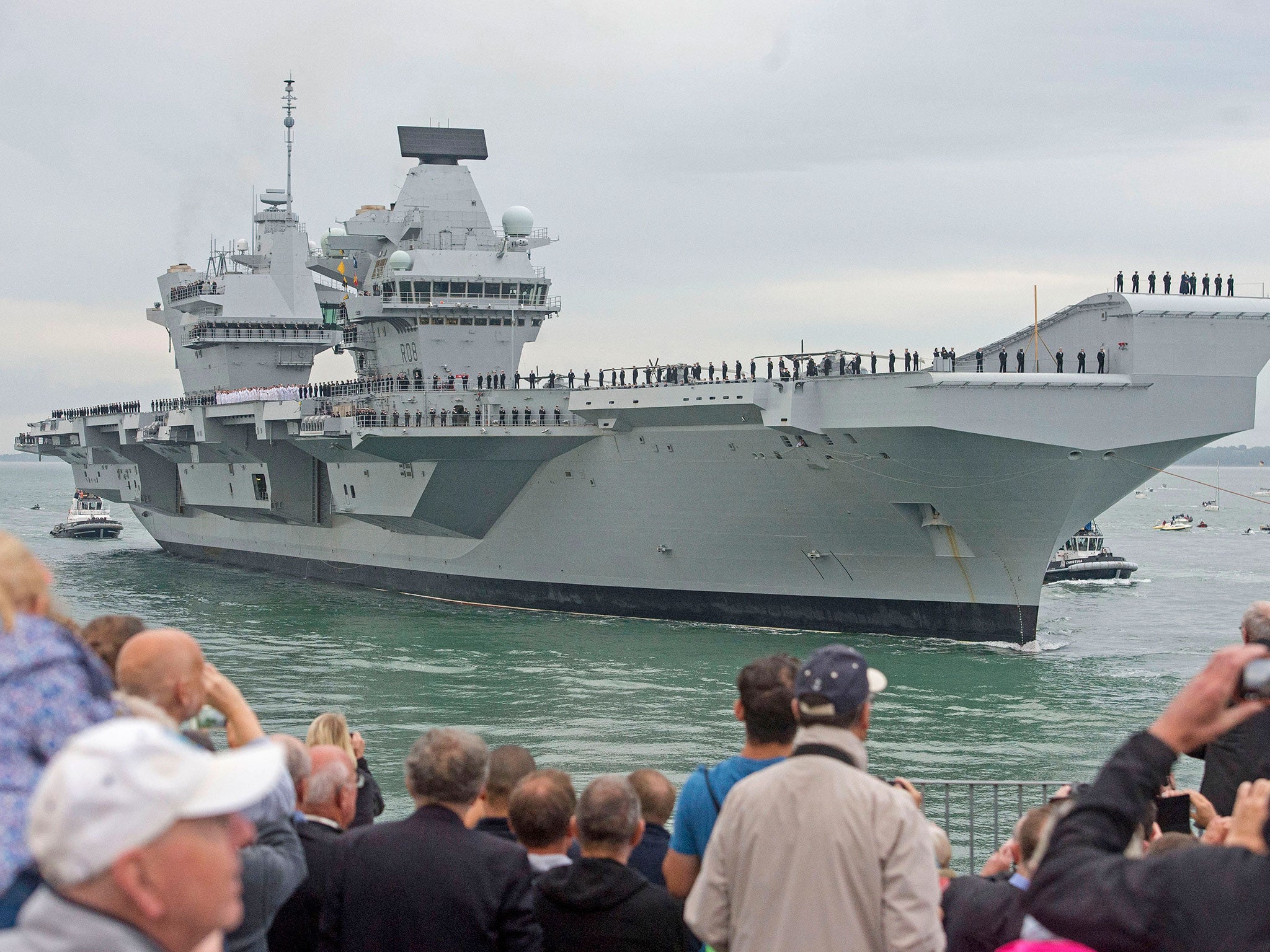 Crowds watch as HMS Queen Elizabeth, the UK's newest aircraft carrier, arrives in Portsmouth.