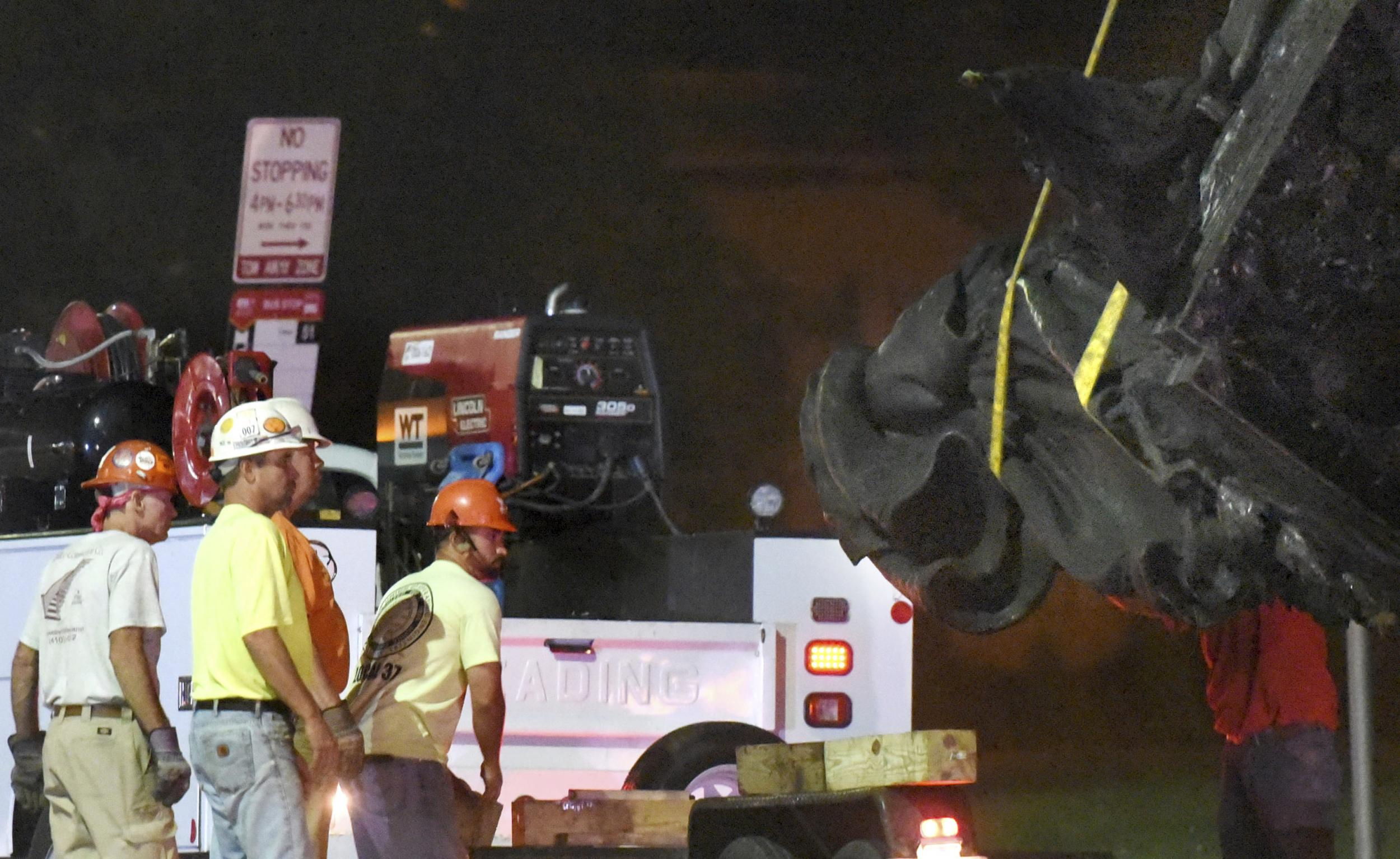 Workers in Baltimore are pictured removing a Confederate monument there
