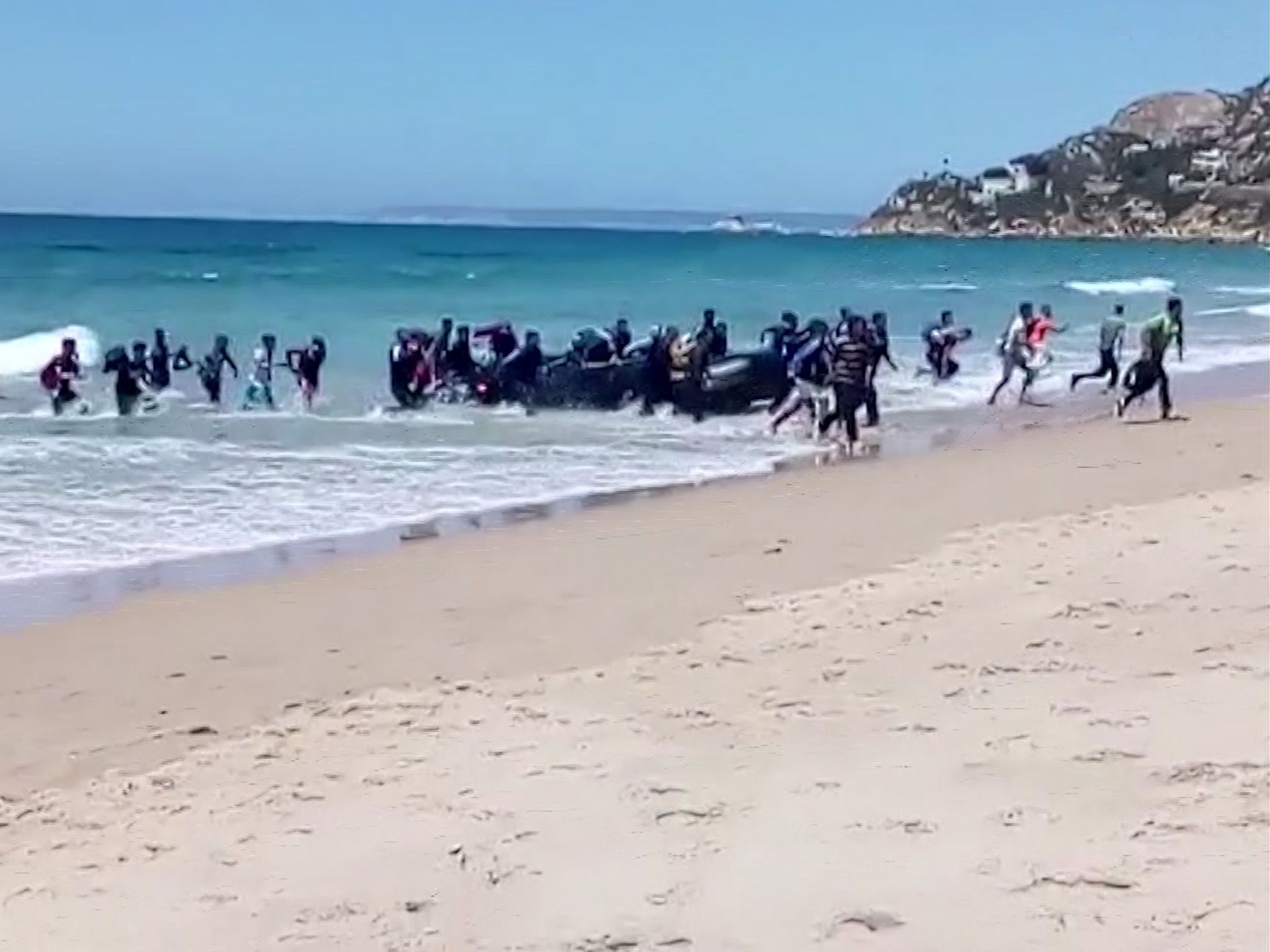 Beachgoers in Cadiz in southern Spain were surprised to see two dozen refugees disembark from a dinghy