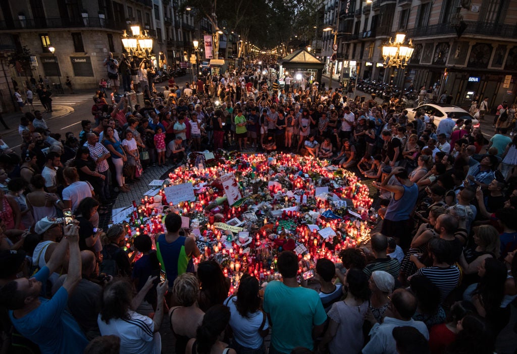 People gather around tributes laid on Las Ramblas near to the scene of the terrorist attack in Barcelona