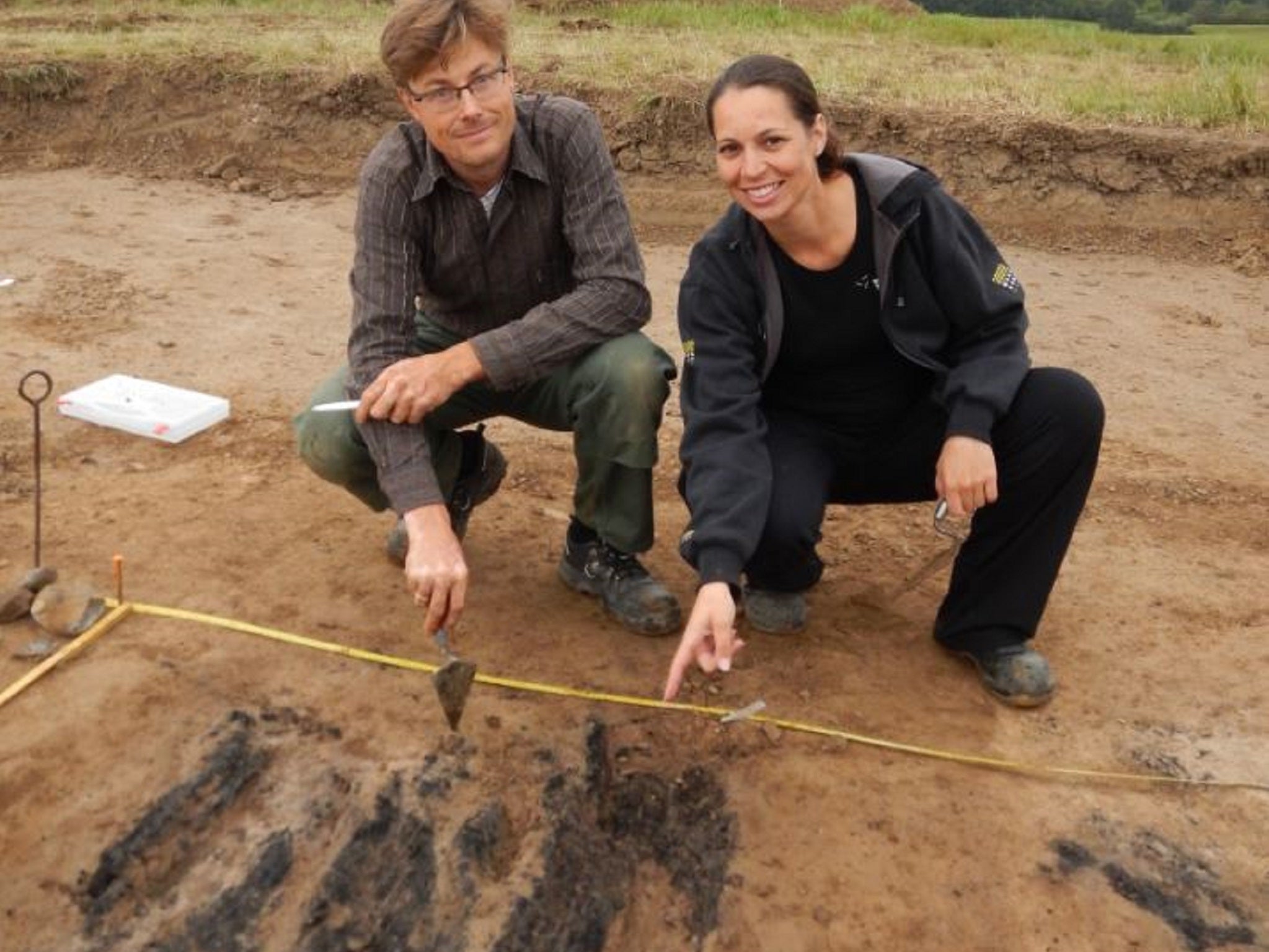 Researchers Søren M. Sindbæk and Nanna Holm show the remains of the charred planks at one of the gateways to the fortress