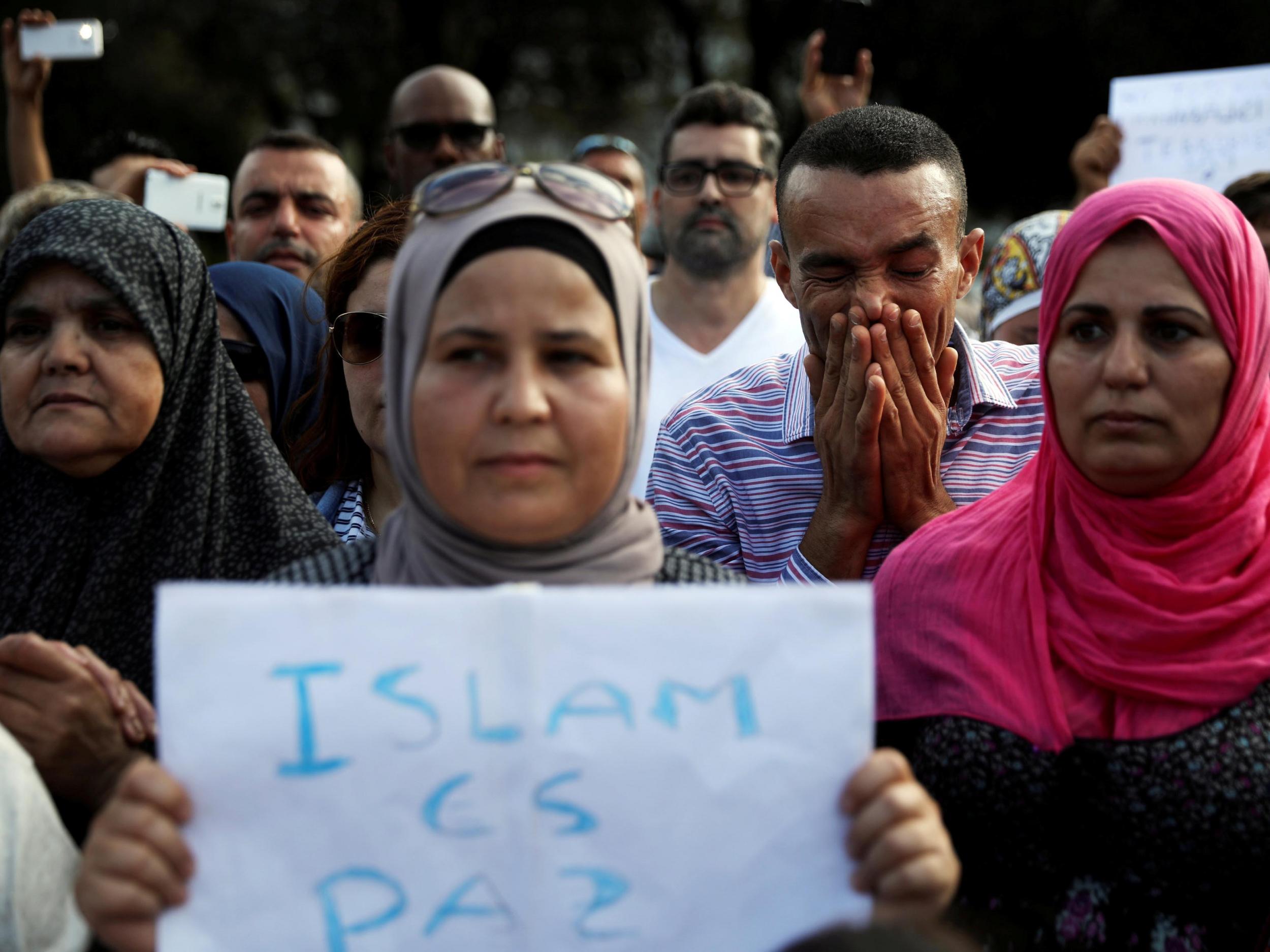 Members of Barcelona's Muslim community observe a minute's silence during a gathering to denounce terrorism near the area where a van crashed into pedestrians at Las Ramblas. The sign reads: 'Islam is peace'