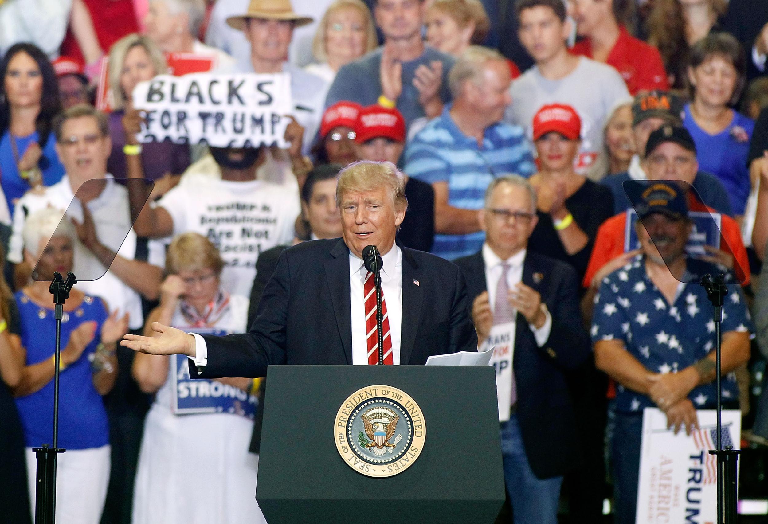 Donald Trump gestures to the crowd as he speaks to supporters at the Phoenix Convention Center