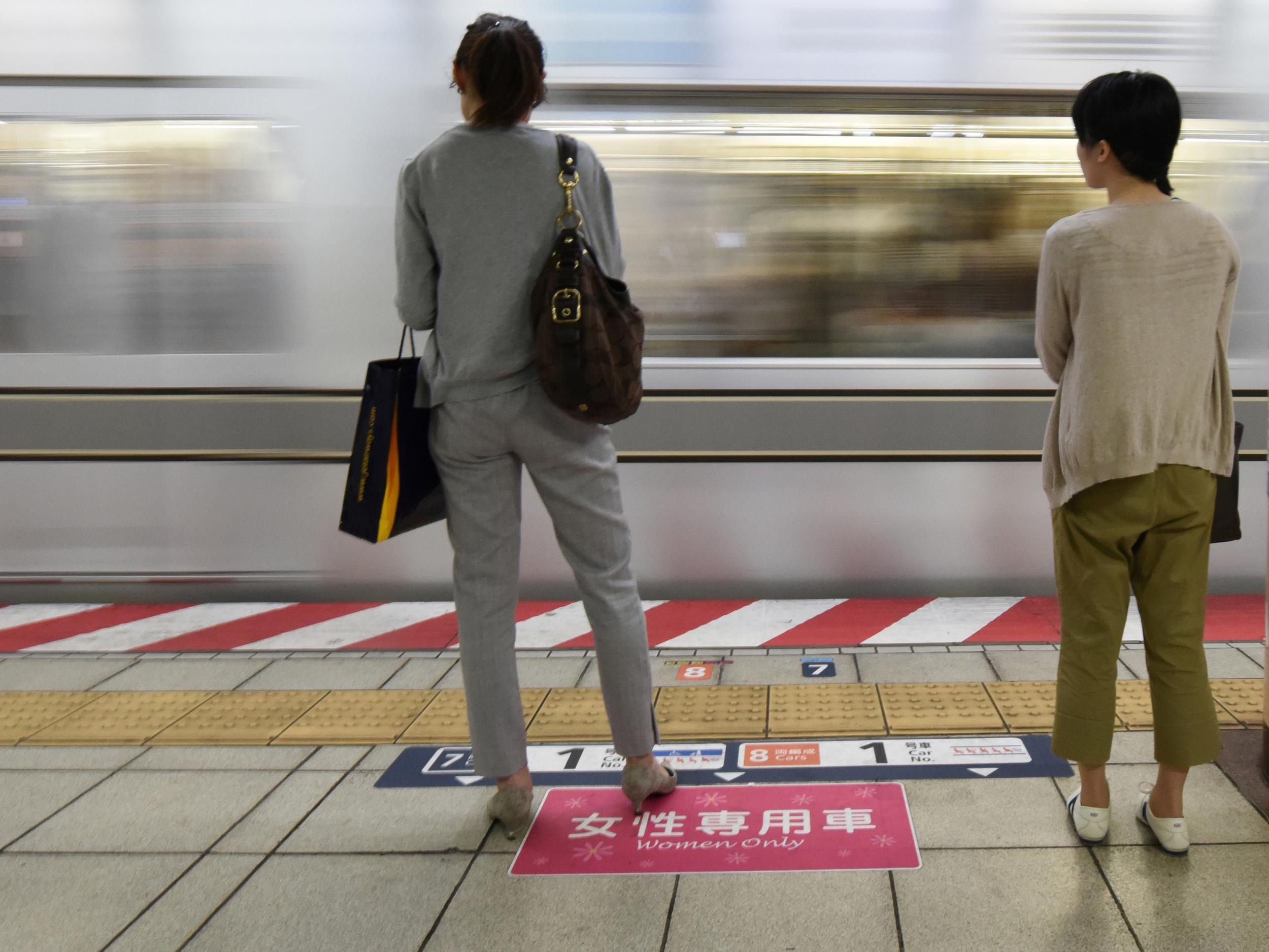 Women wait to board a women's-only carriage onboard a train on a subway station platform in Tokyo