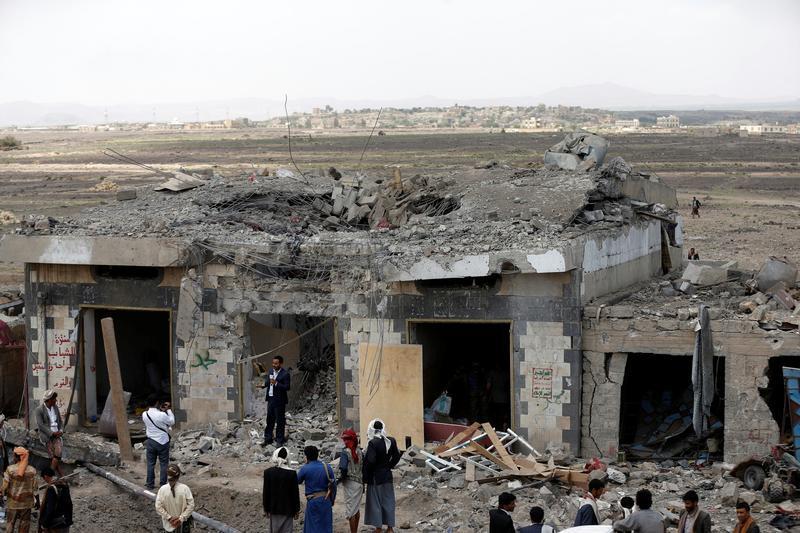 People gather at the site of Saudi-led air strikes in Arhab near Sanaa on 23 August 2017