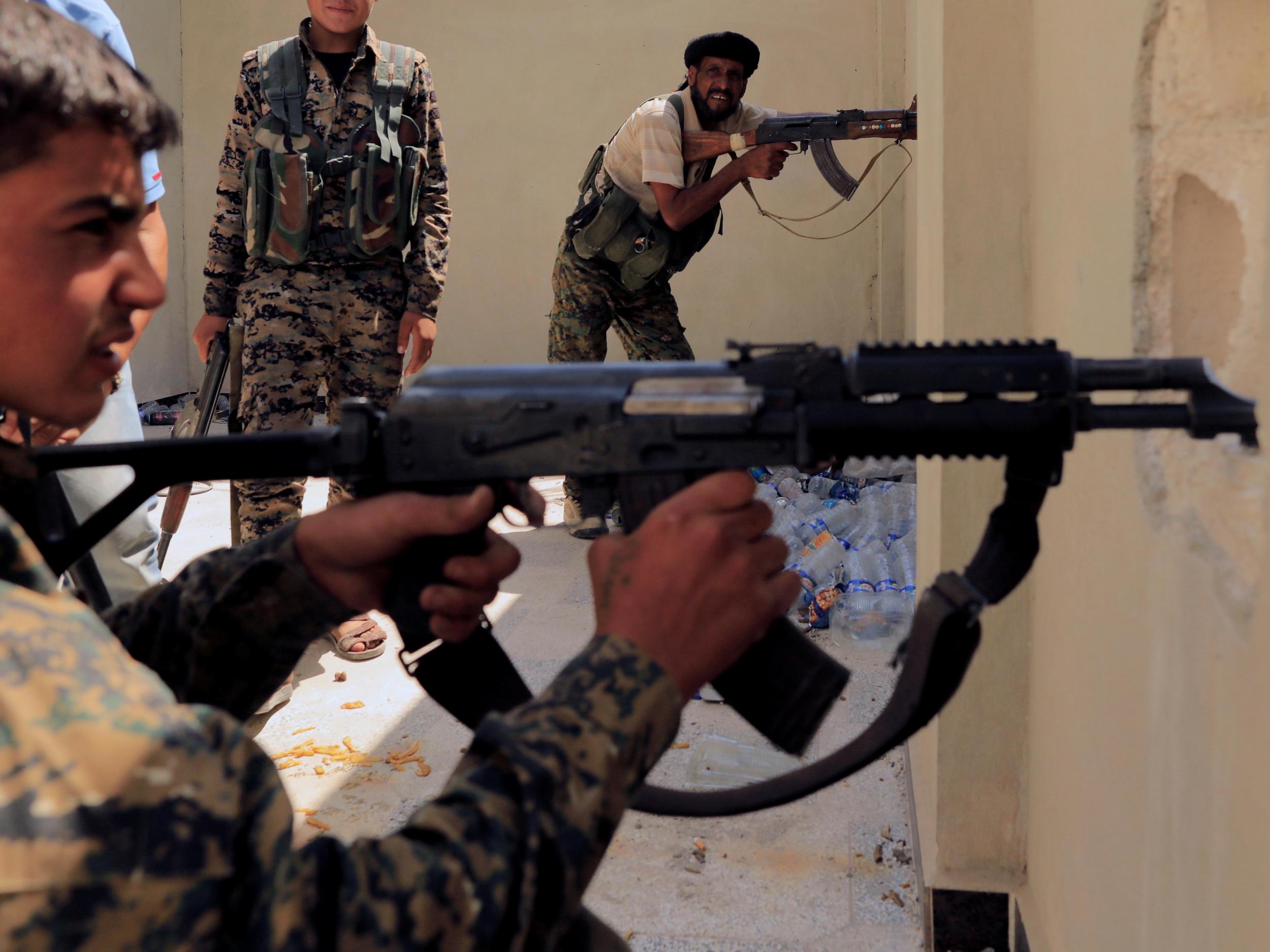 Members of the Syrian Democratic Forces try to locate an Isis sniper in Al Senaa, a district of Raqqa, on 10 August 2017