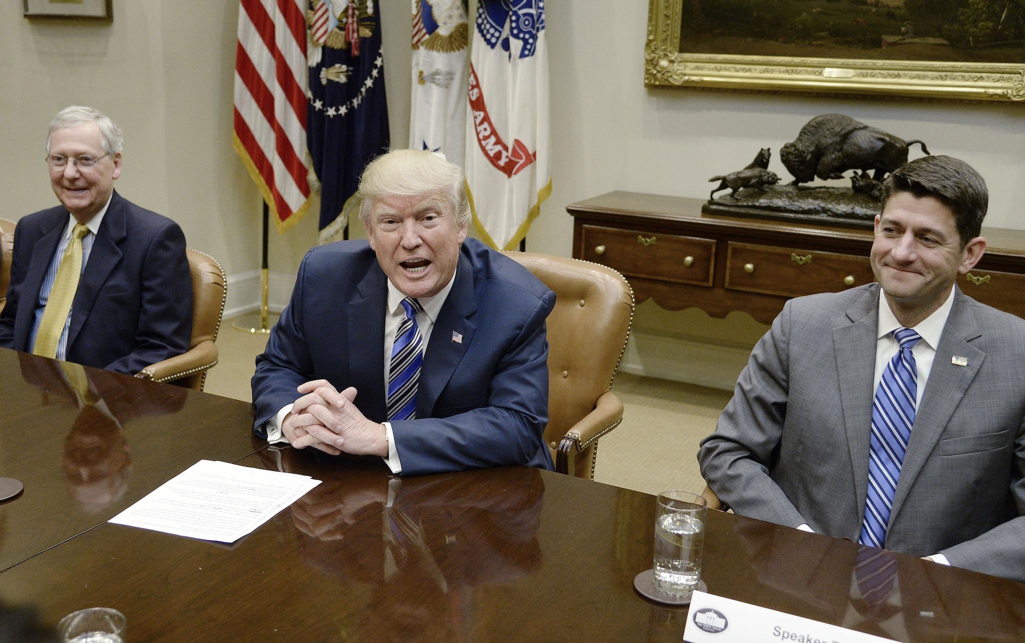 The President speaks as Senate Majority Leader Mitch McConnell and House Speaker Paul Ryan listen