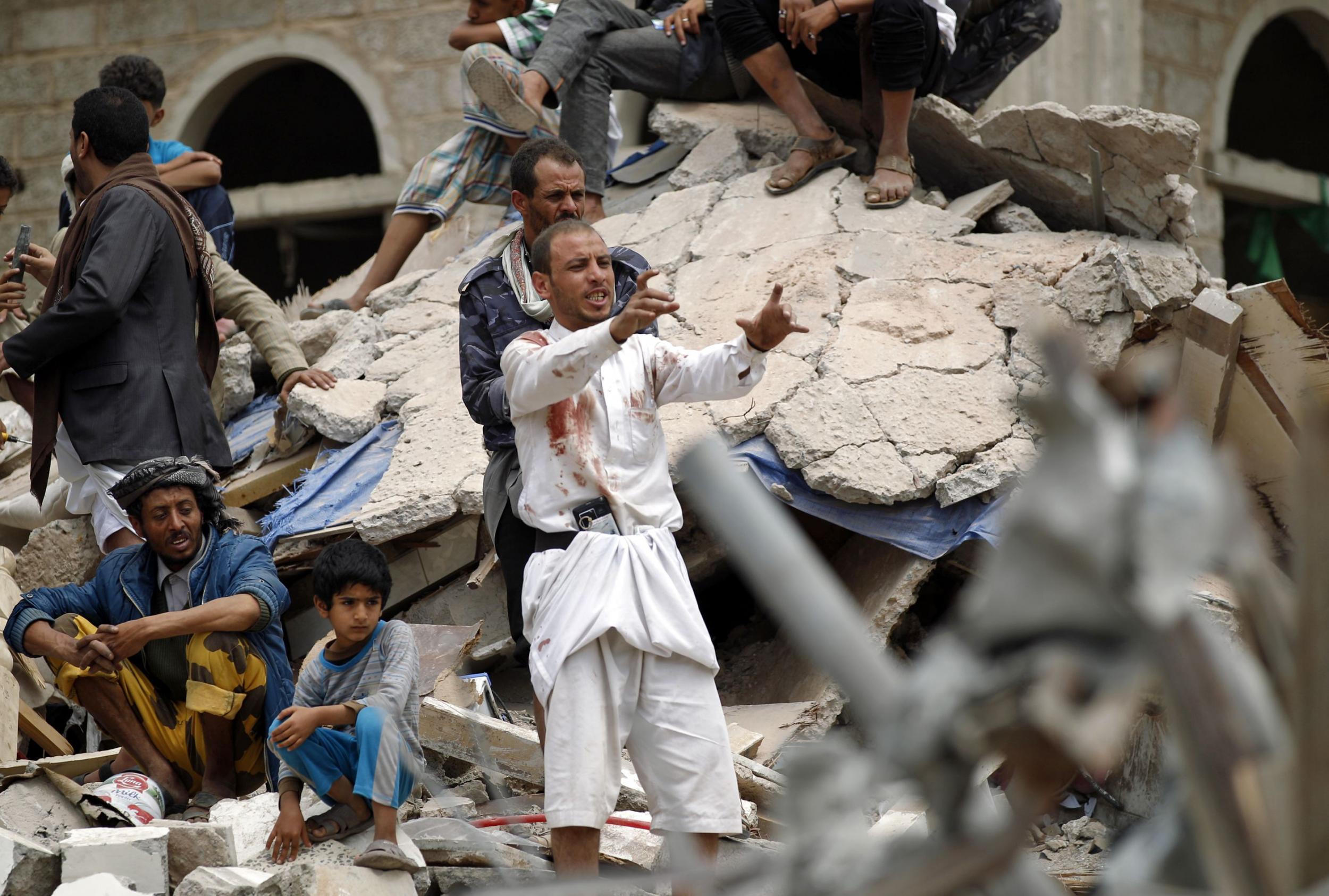 A Yemeni man covered in blood stains reacts as rescuers search for survivors in the debris of buildings inSanaa(AFP/GettyImages)